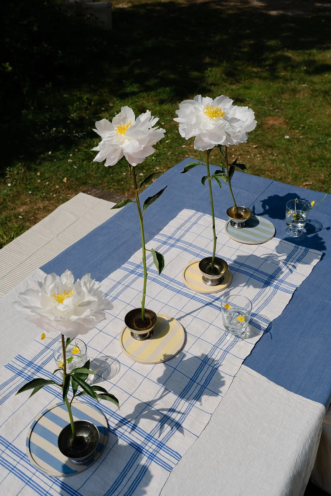 Open white peonies for table set up for a private garden party with bespoke linens
