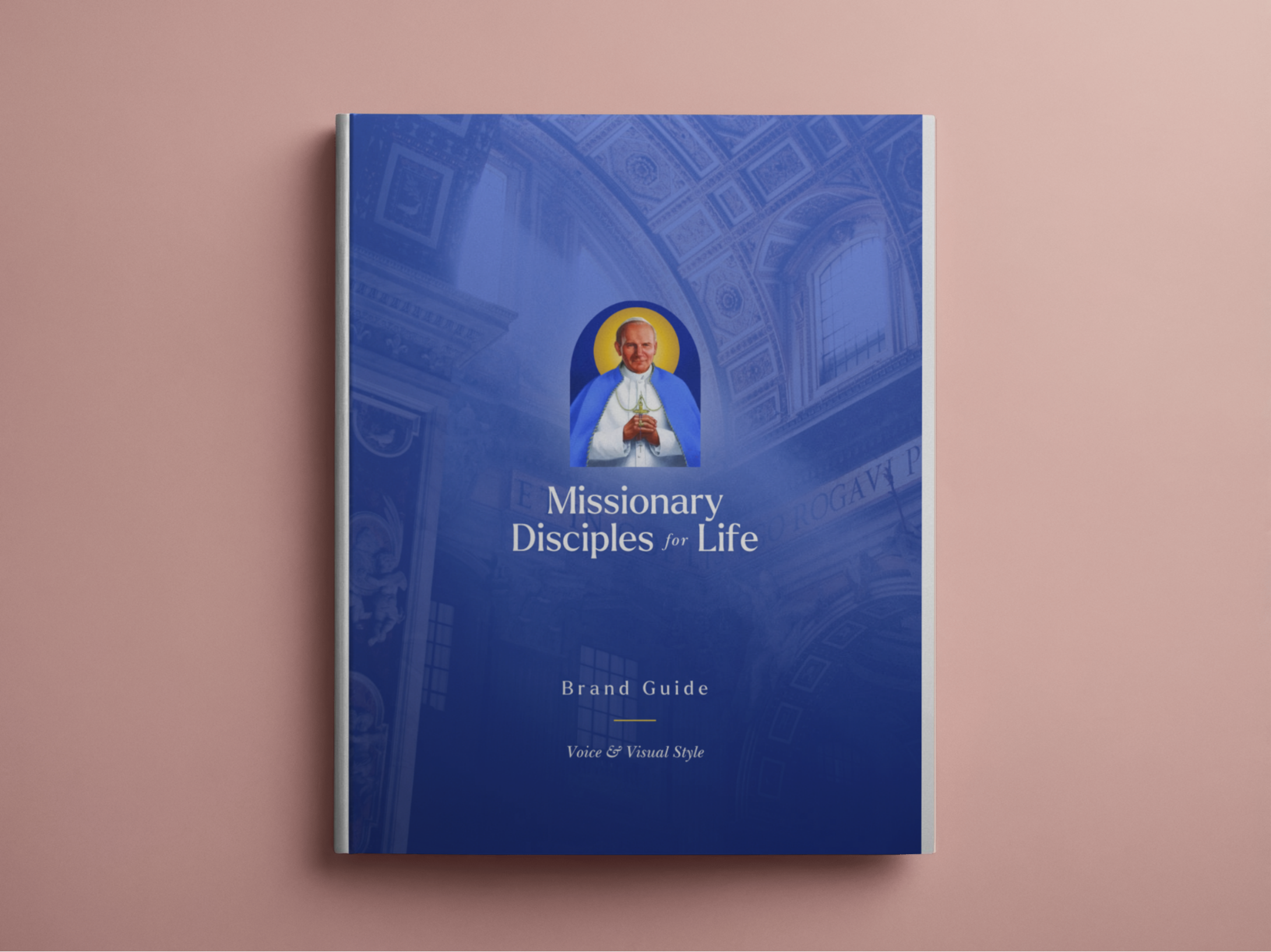 Blue book titled 'Missionary Disciples for Life' with an image of a bishop on its cover, placed on a pink surface.