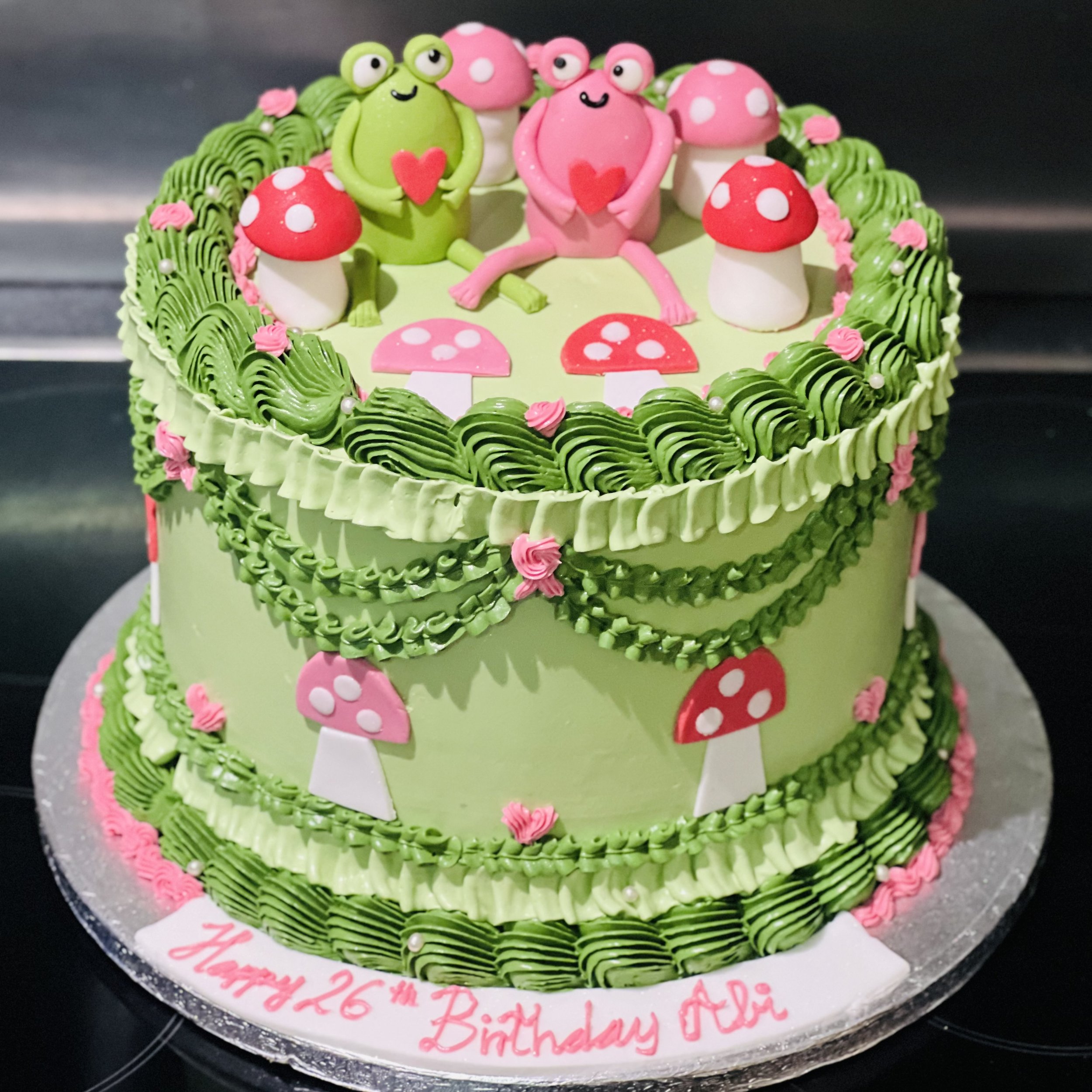 Vintage-style heart-shaped birthday cake in blush pink and ivory, decorated with pearls and ribbons.