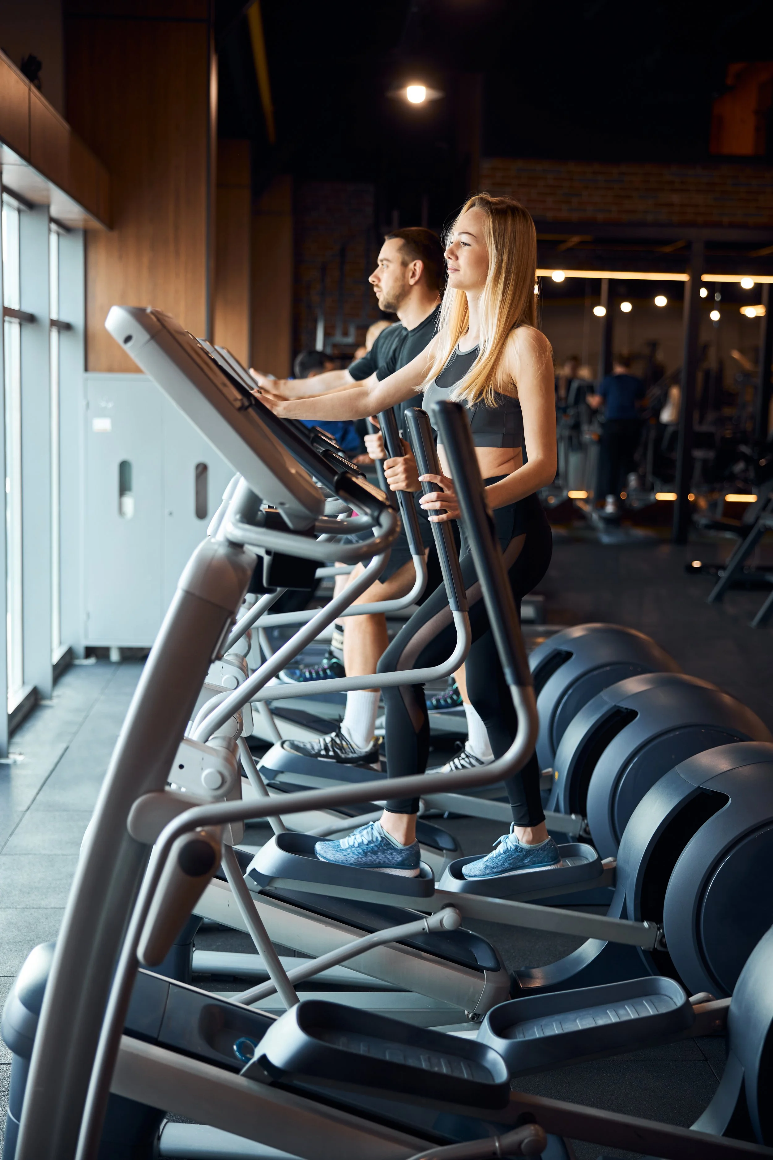People walking on treadmills in a gym.