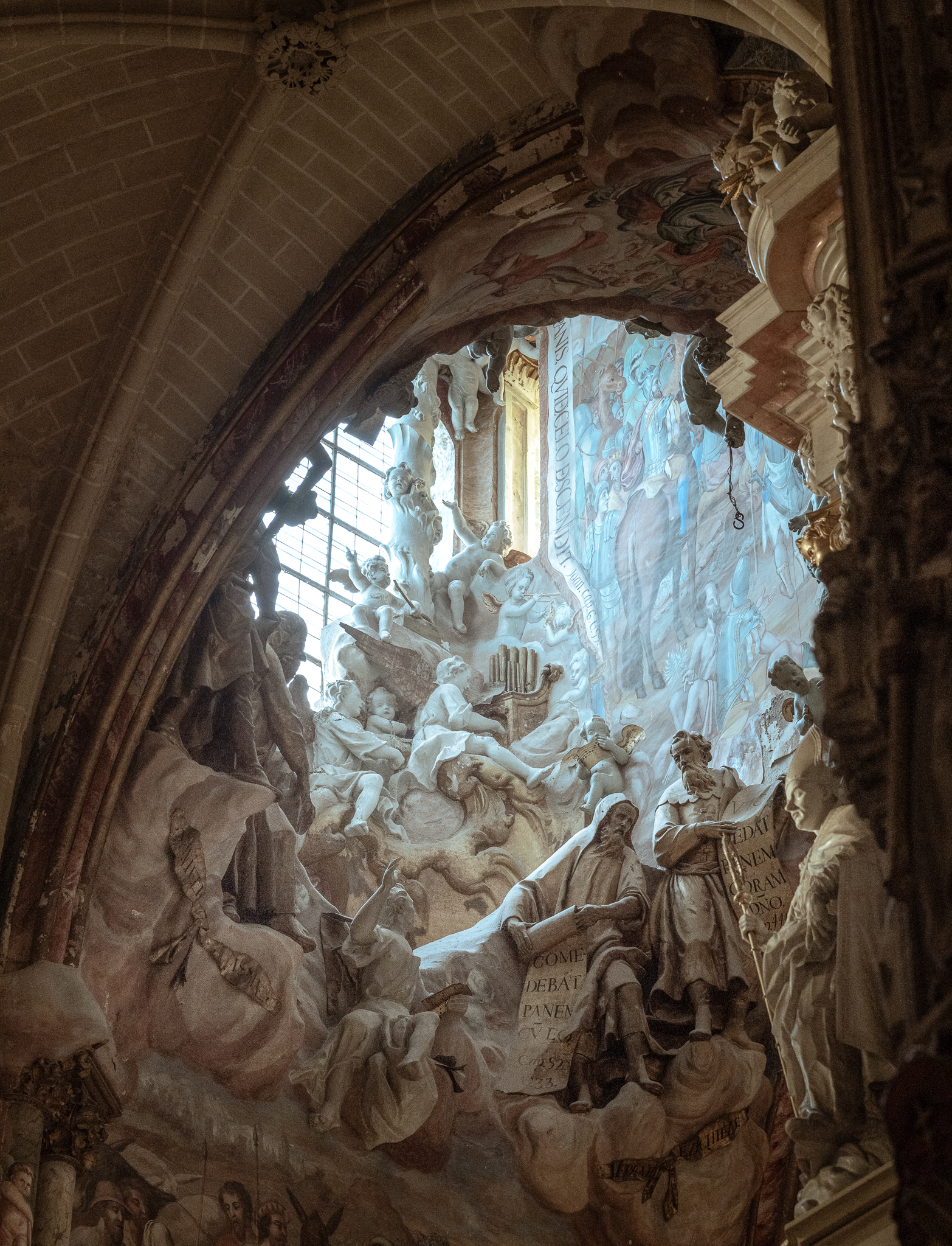 Daylight opening through the ambulatory vault at Toledo Cathedral’s Transparente, surrounded by sculpted figures and painted surfaces by Narciso Tomé.