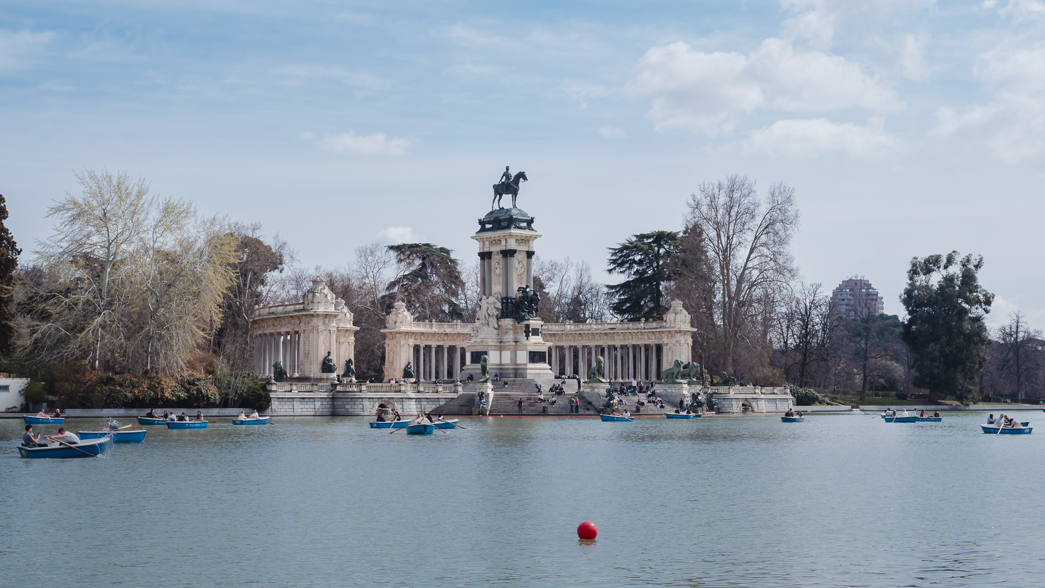 Monument to Alfonso XII across the Estanque Grande boat lake in El Retiro Park, Madrid, with rowing boats on the water