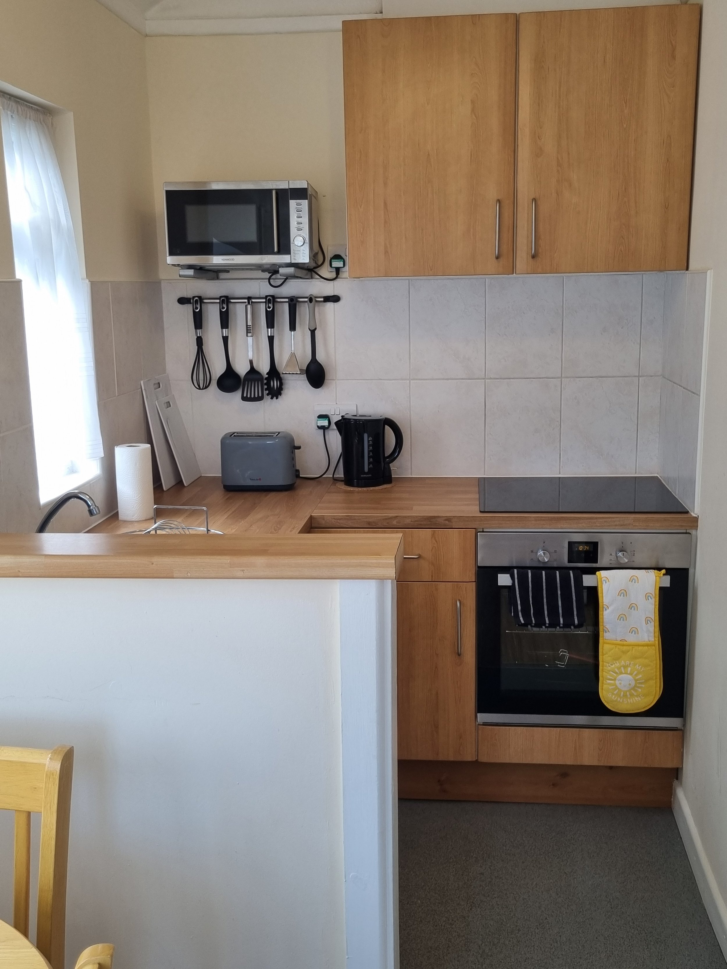 Kitchen with full-size electric oven, four-ringed electric hob.