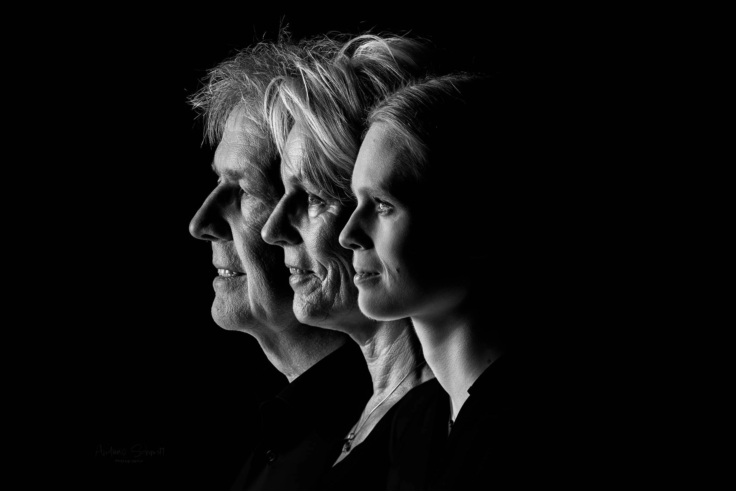 Drei Menschen in Profilansicht vor schwarzem Hintergrund, älterer Mann, ältere Frau, jüngere Frau, in Schwarz-Weiß