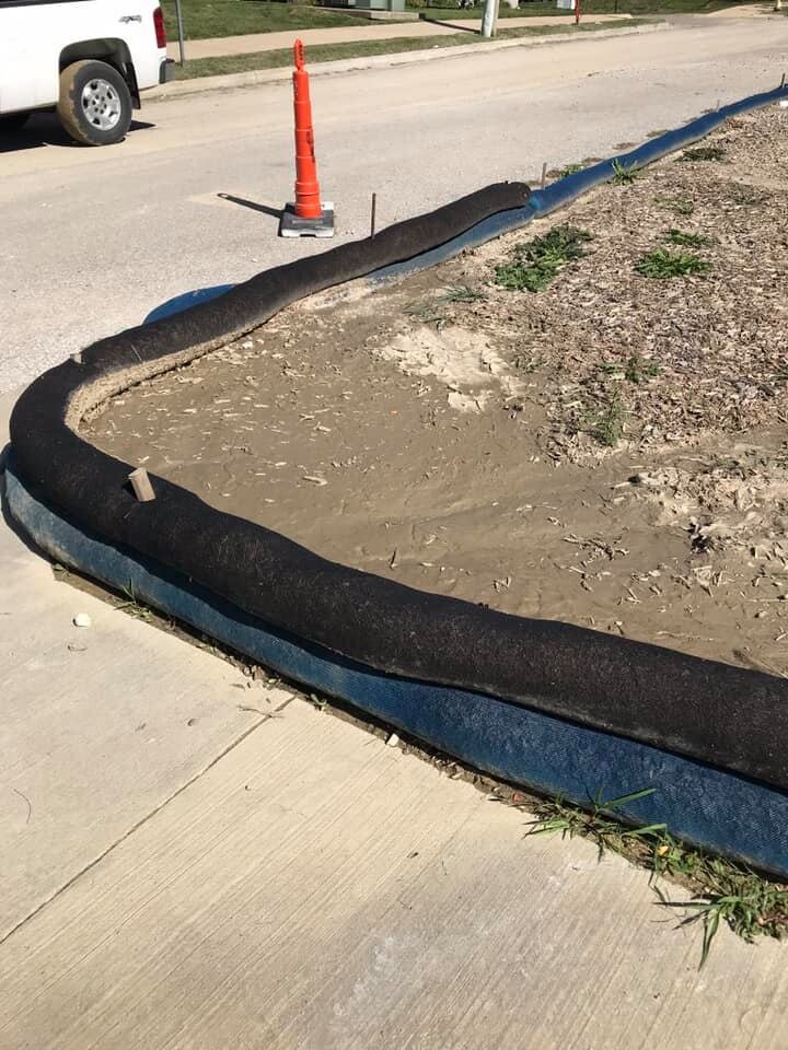 etube filter sock installed along the back of a curb to prevent sediment from washing out onto the pavement.