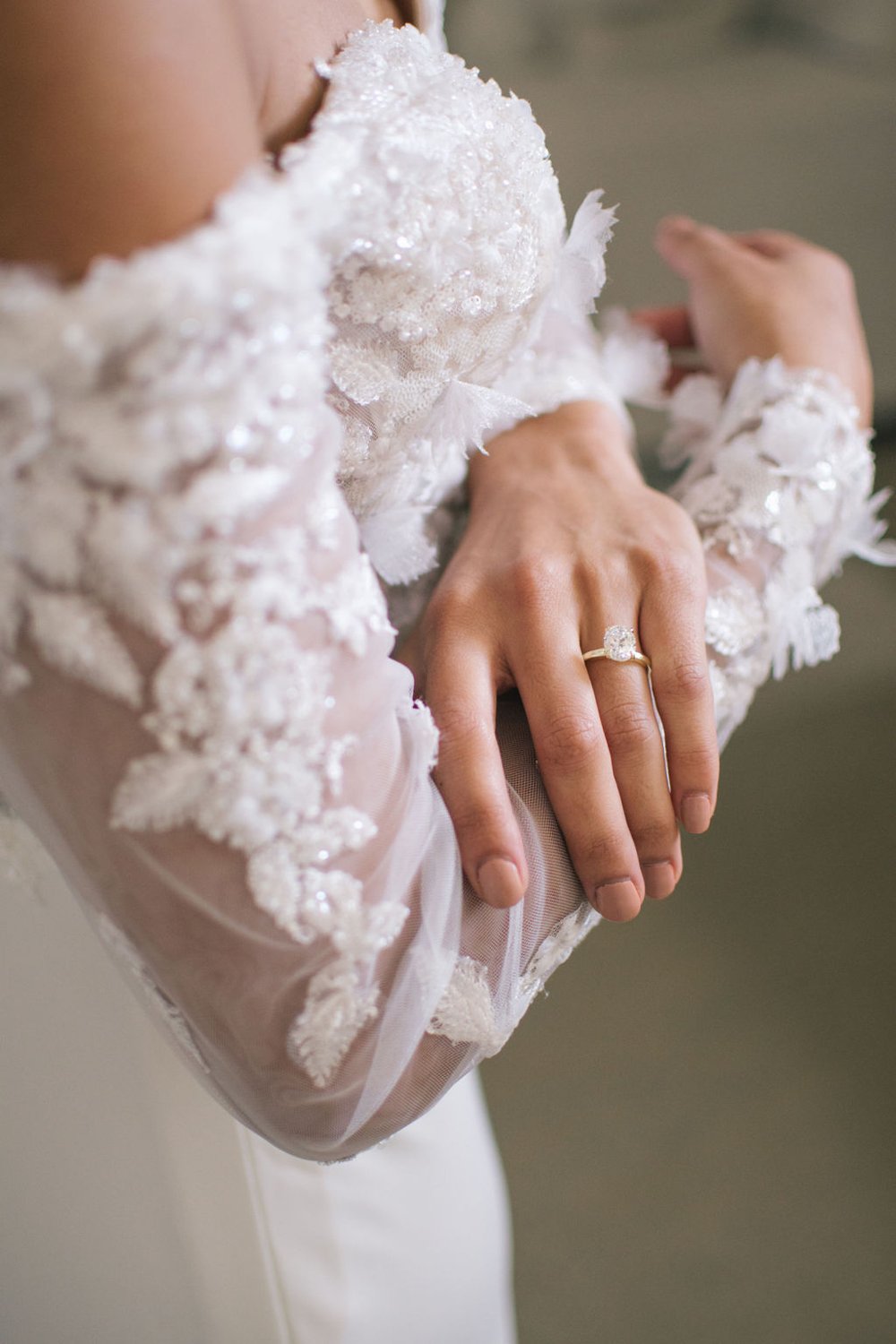 Lace wedding gown with a gold solitaire wedding engagement ring.