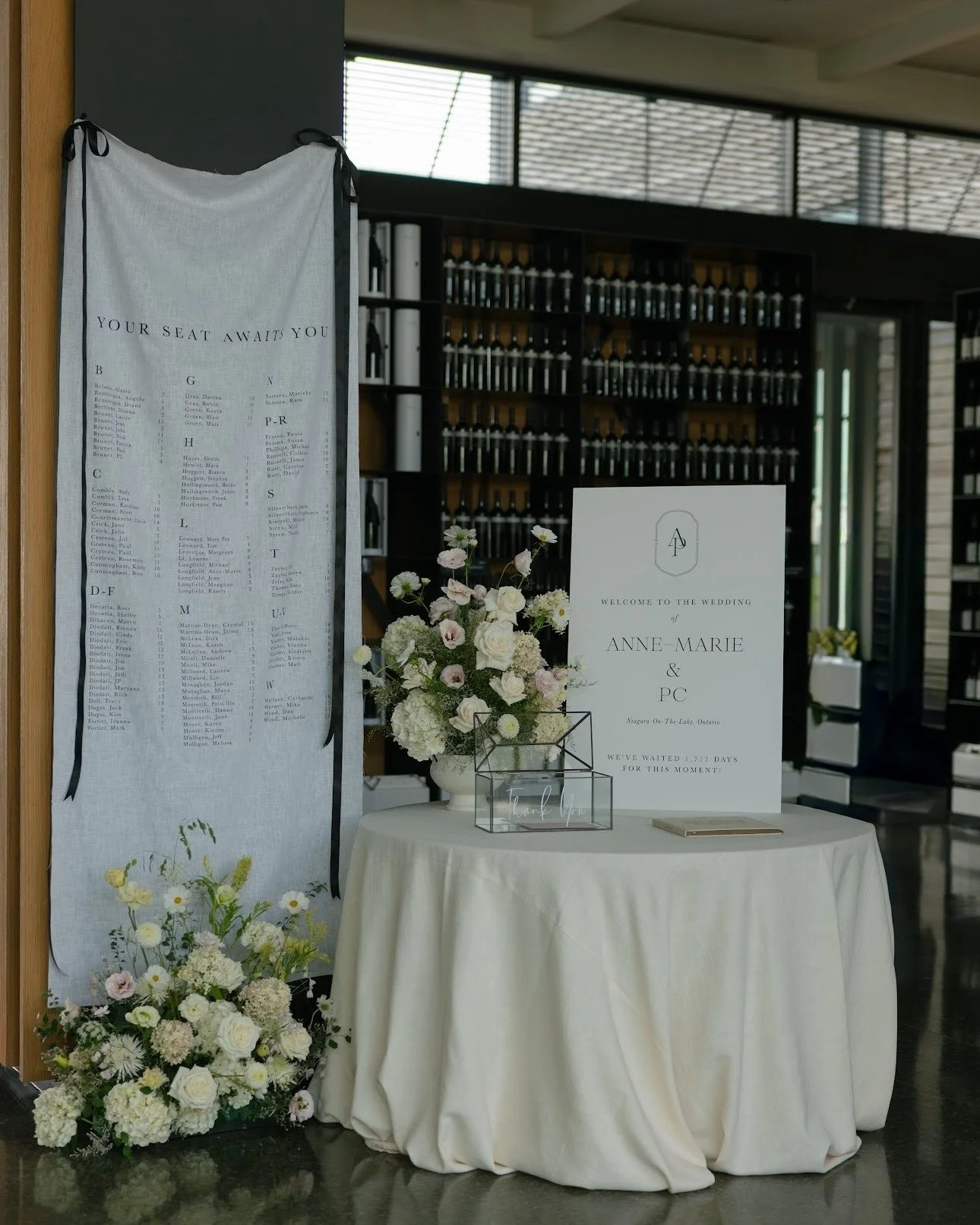 Soft textures against sleek lines 🖤

There is nothing quite like the movement of a hanging linen seating chart to welcome guests into the @stratuswines tasting room. Anchored by romantic florals and dark ribbon accents, this focal point is the perfe