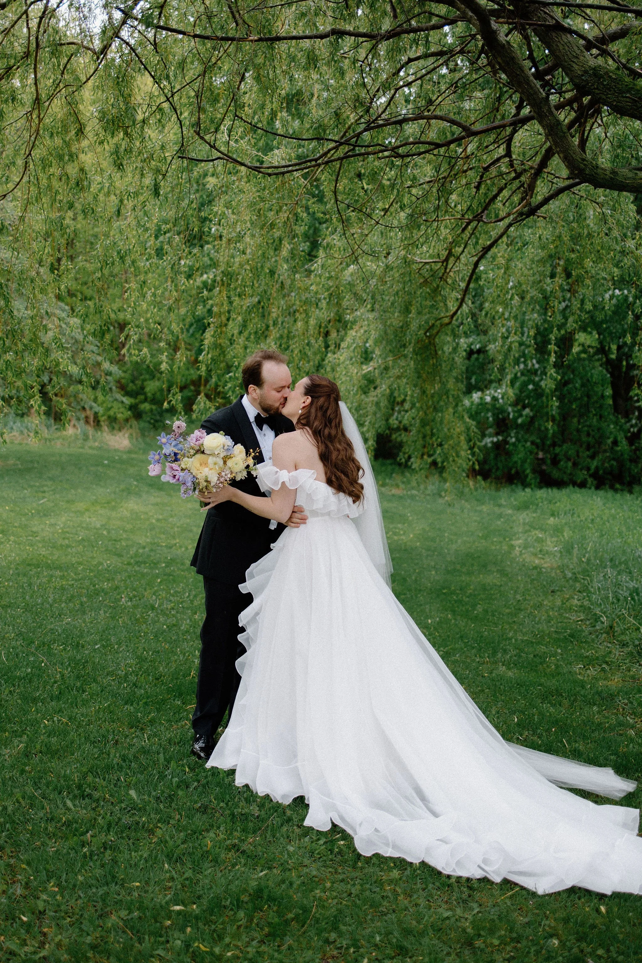  Groom and Bride share their first kiss at their first look under the willow trees at The Clearing, Sheddon. 