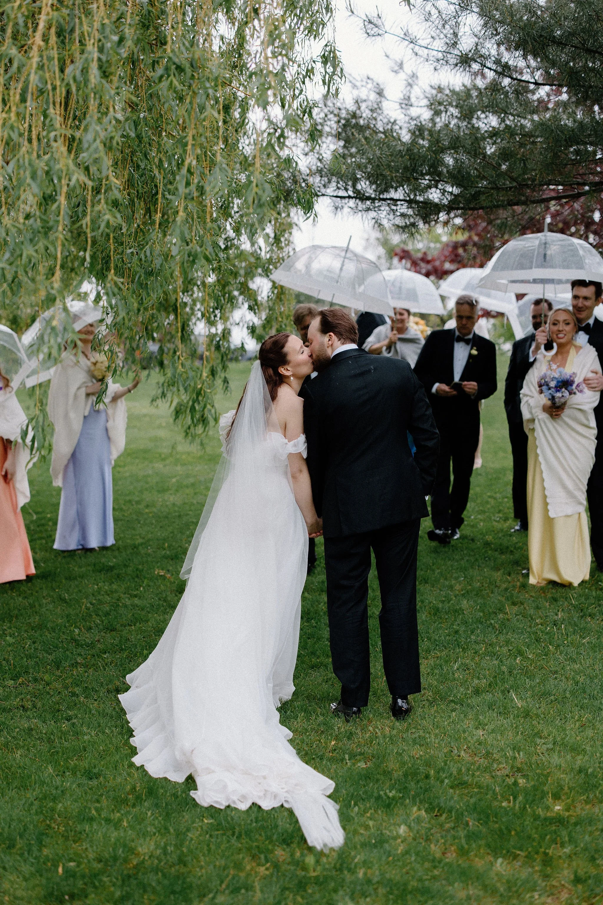  Proving that a little rain only adds to the romance, L+M’s wedding at The Clearing was an absolute dream. Nestled in the trees, this outdoor celebration embraced a whimsical garden aesthetic, brought to life by a vibrant, cheerful colour palette of 