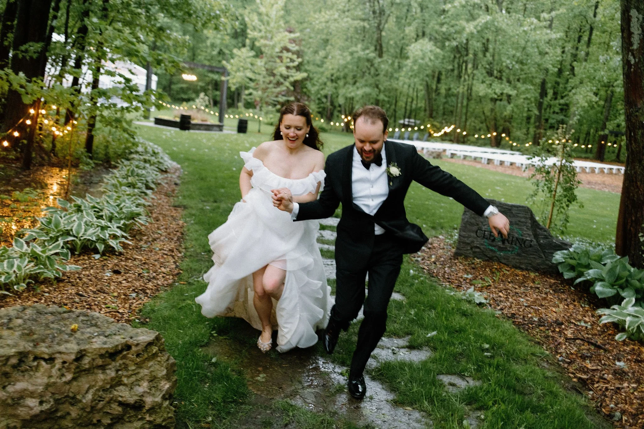  There is something so cinematic about rain under camera flashes at night. To wrap up this whimsical wedding day at The Clearing, the couple snuck away from their clear-top tent reception to splash in the puddles. The resulting nighttime wedding phot