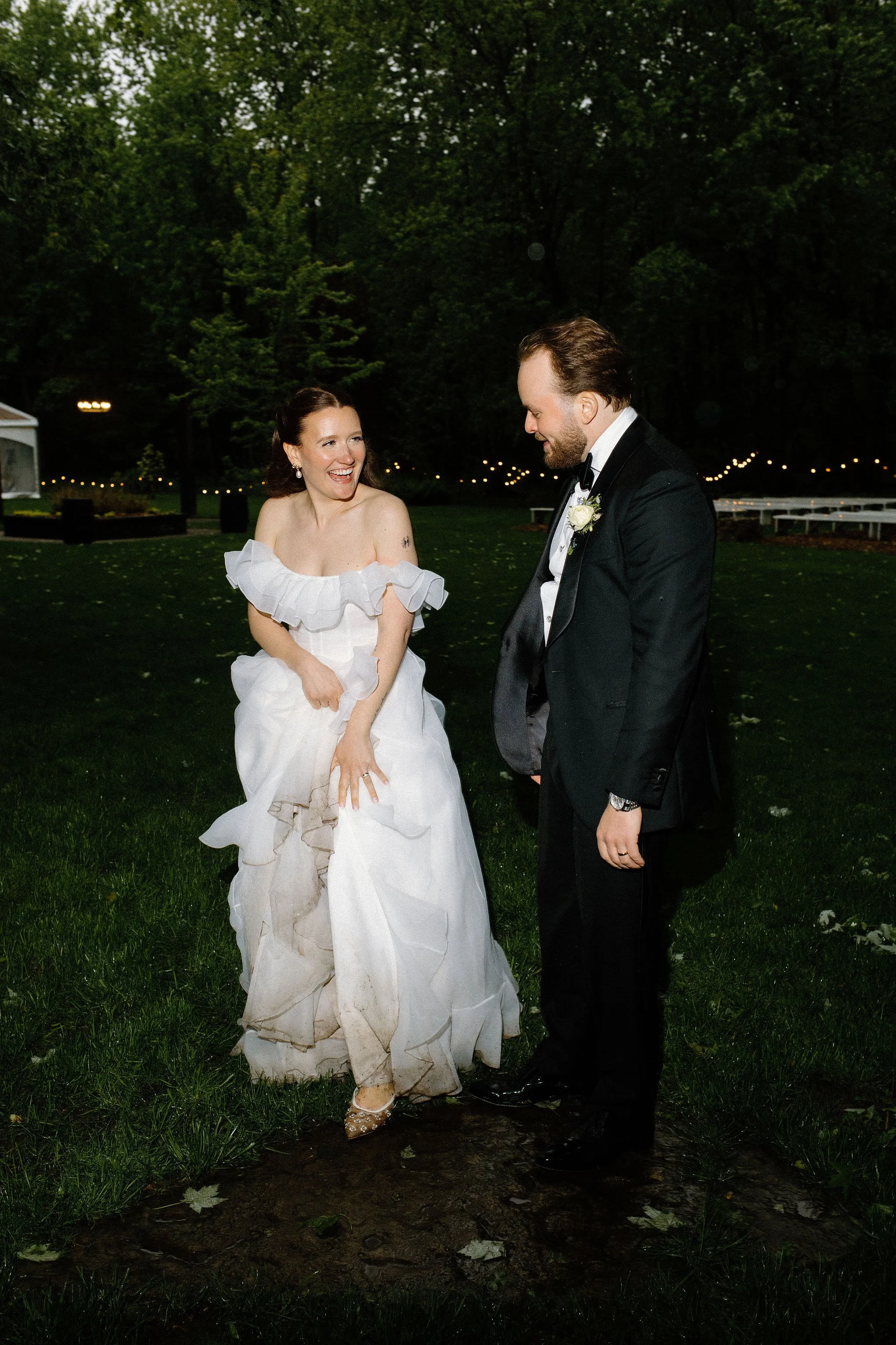  There is something so cinematic about rain under camera flashes at night. To wrap up this whimsical wedding day at The Clearing, the couple snuck away from their clear-top tent reception to splash in the puddles. The resulting nighttime wedding phot