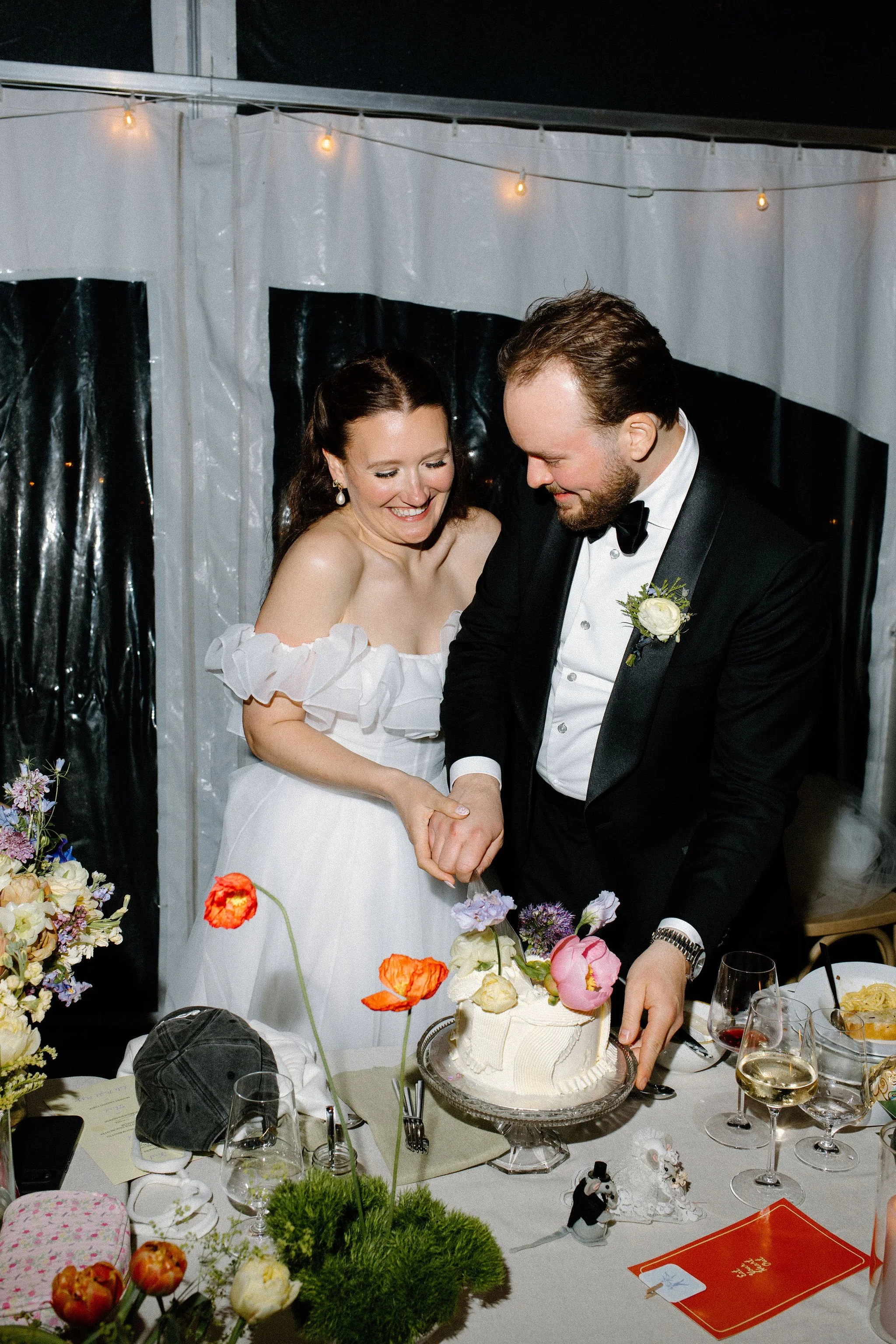  The couple is all smiles cutting into their cake before dance floor opens with their wedding at The Clearing in London, Ontario. 