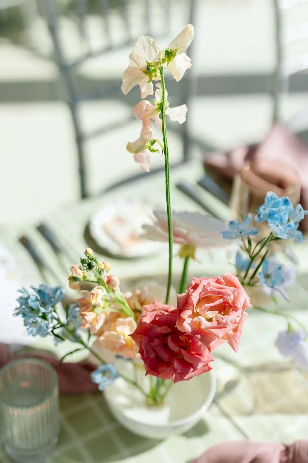  Delicate, airy centerpieces featured a romantic mix of pillowy white peonies, blush ranunculus, and sky-blue delphinium, creating a refined "just-picked" look 