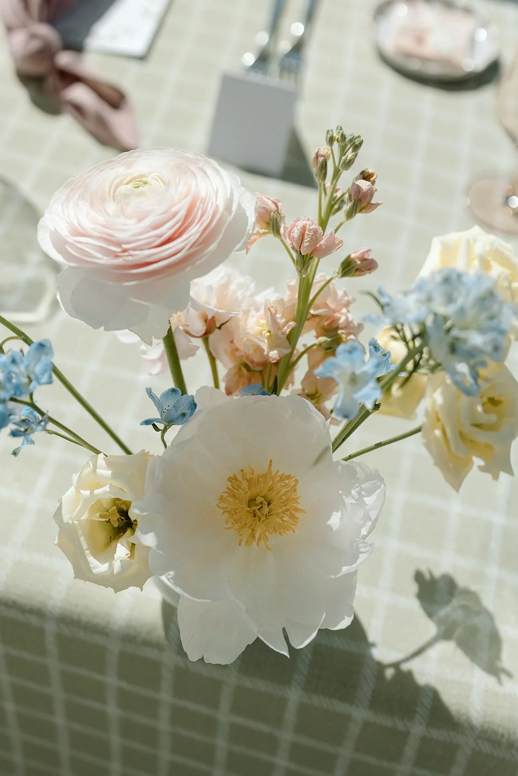  A macro shot of the centerpiece florals, highlighting the delicate texture of the ranunculus and peony petals. 
