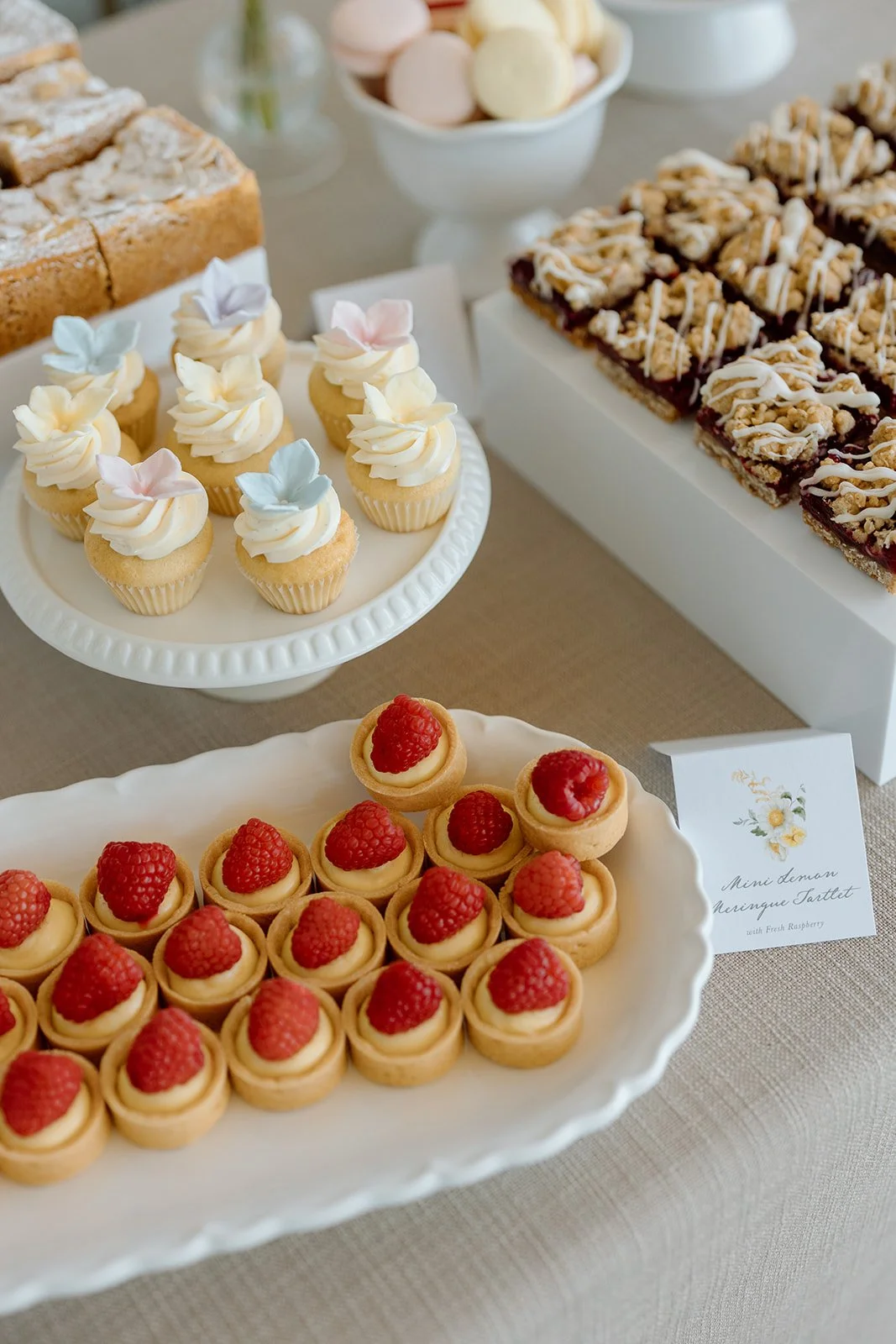  Luxury bridal shower dessert table styling with berry crumble bars and pastel macarons. 