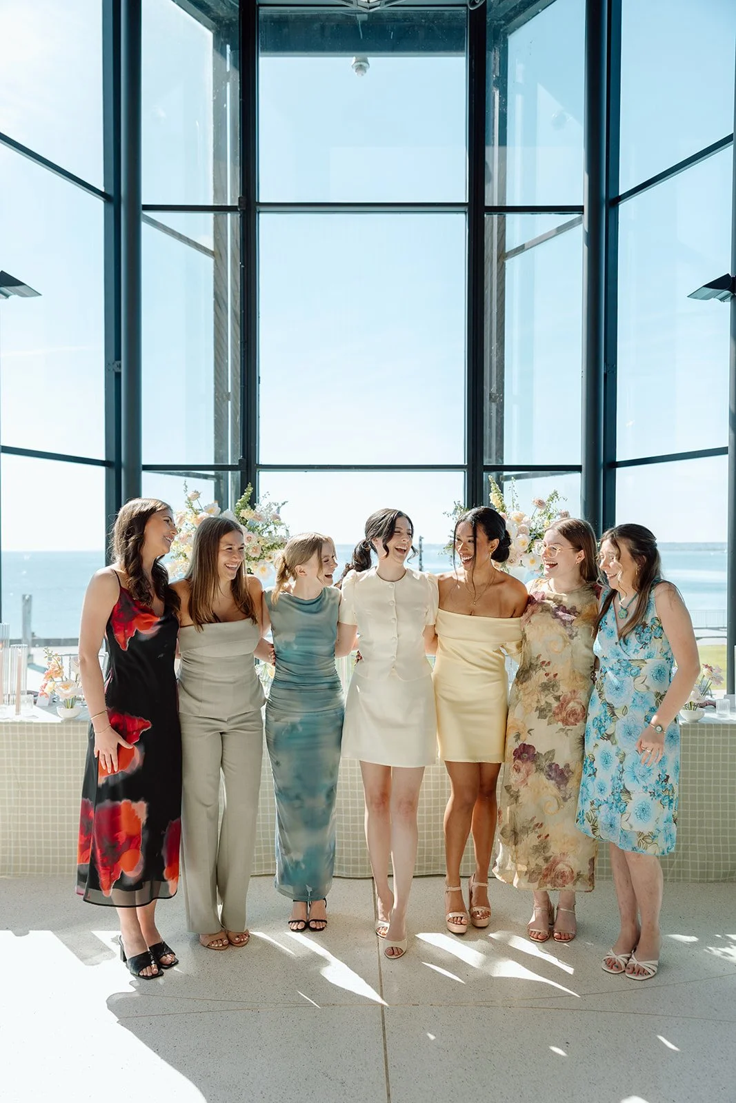  Bride poses with her wedding party infront of the large scale windows at Spencer’s at the Waterfront. 
