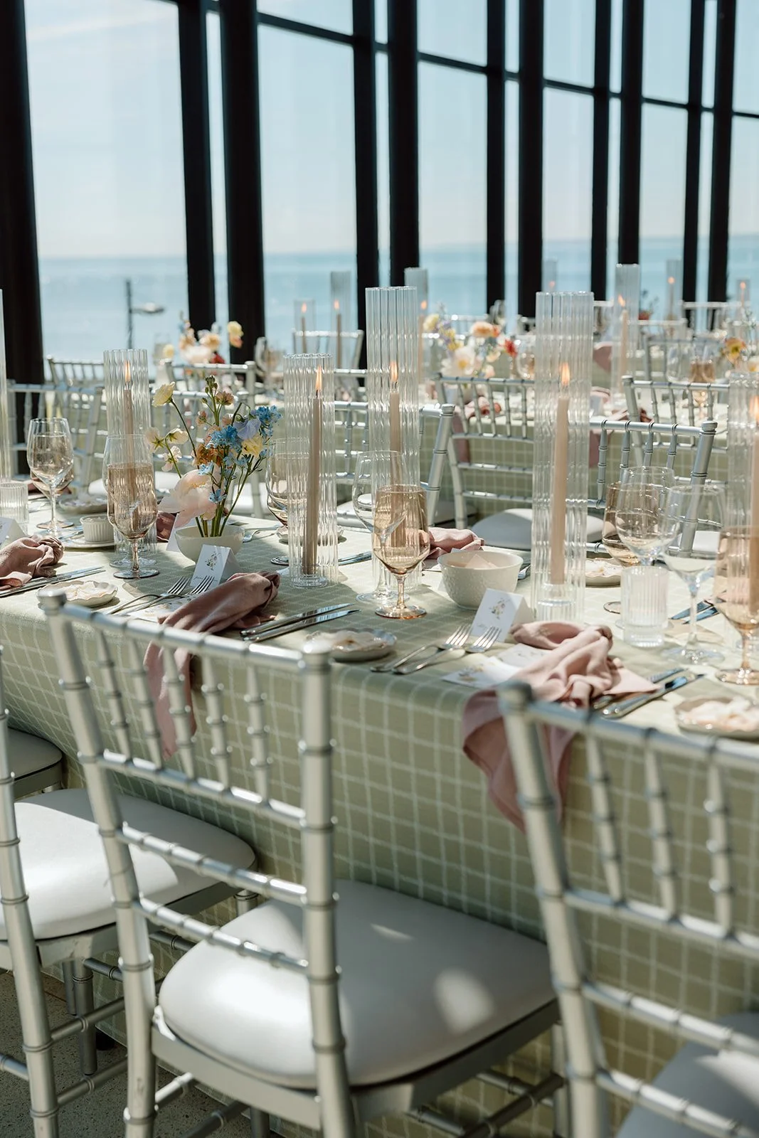  A view down the long family-style tables, emphasizing the romance of the ribbed candle glow against the water. 
