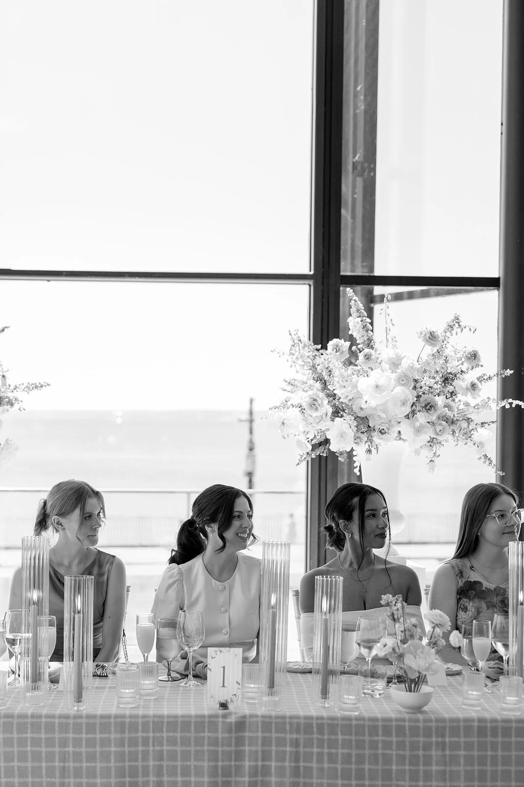  Bridal party sitting at head table surrounded by spring coloured florals. 