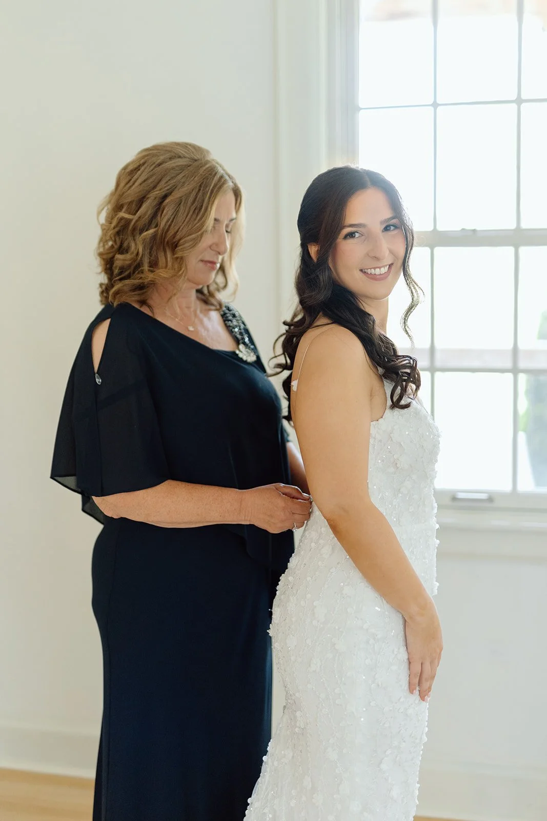  Mother of the Bride helps her daughter into her wedding dress before the first look. Location: Willowfarm House NOTL 