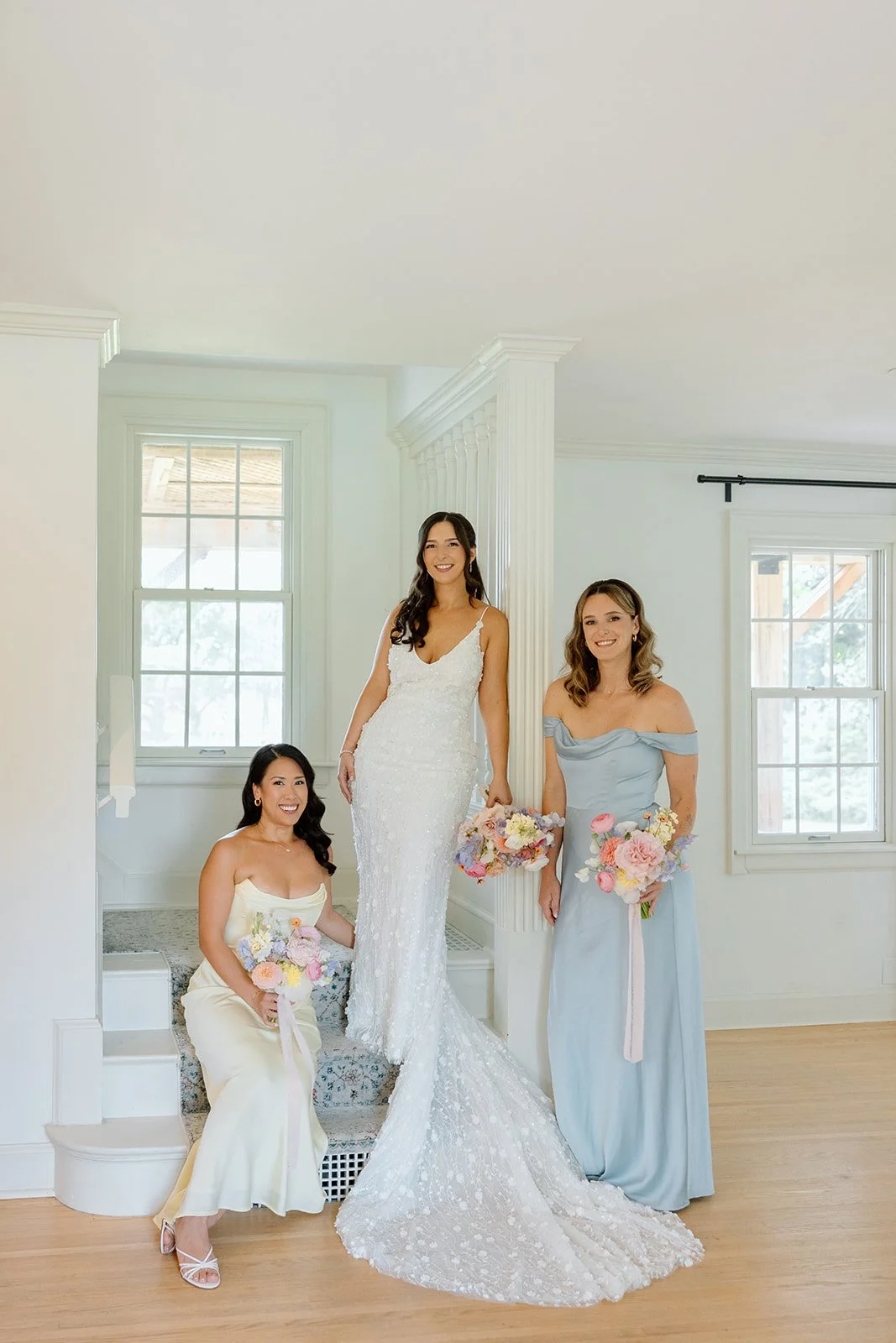  Bright and airy bridal prep photography by Paula Visco featuring a lace bridal gown and pastel bridesmaid dresses. 