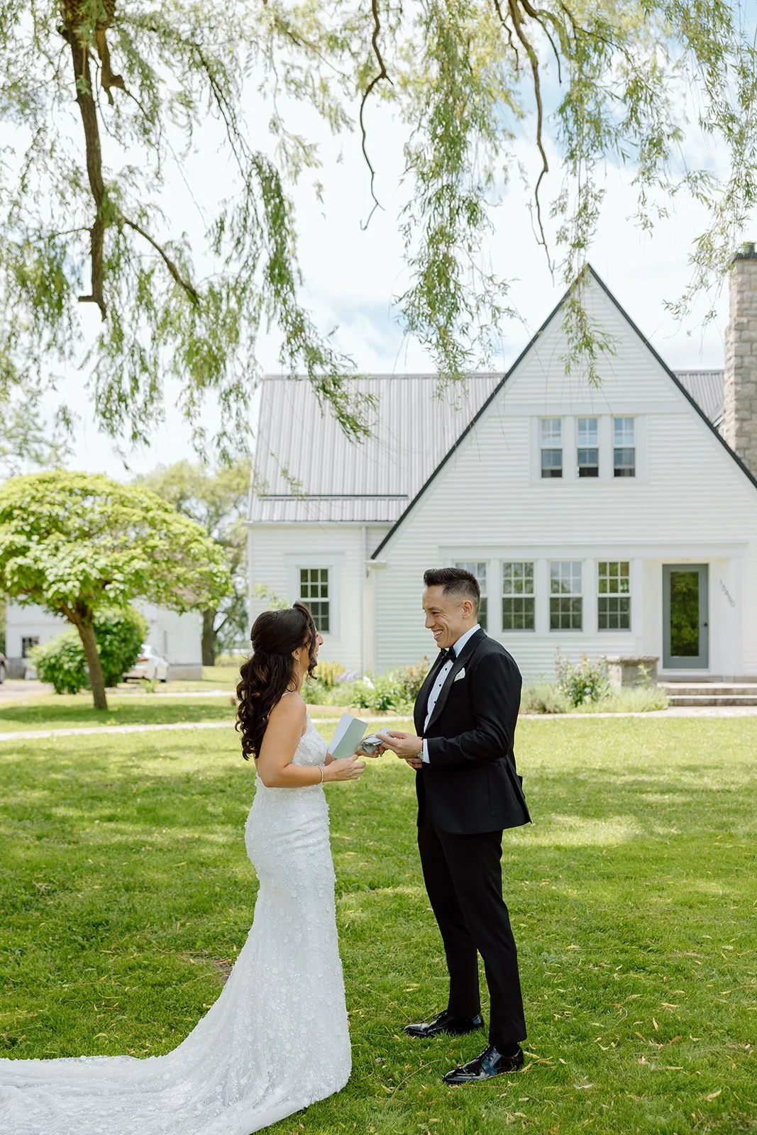  Black and white portrait of a smiling groom in a classic tuxedo at a Niagara-on-the-Lake wedding venue, captured by Paula Visco Photography. 