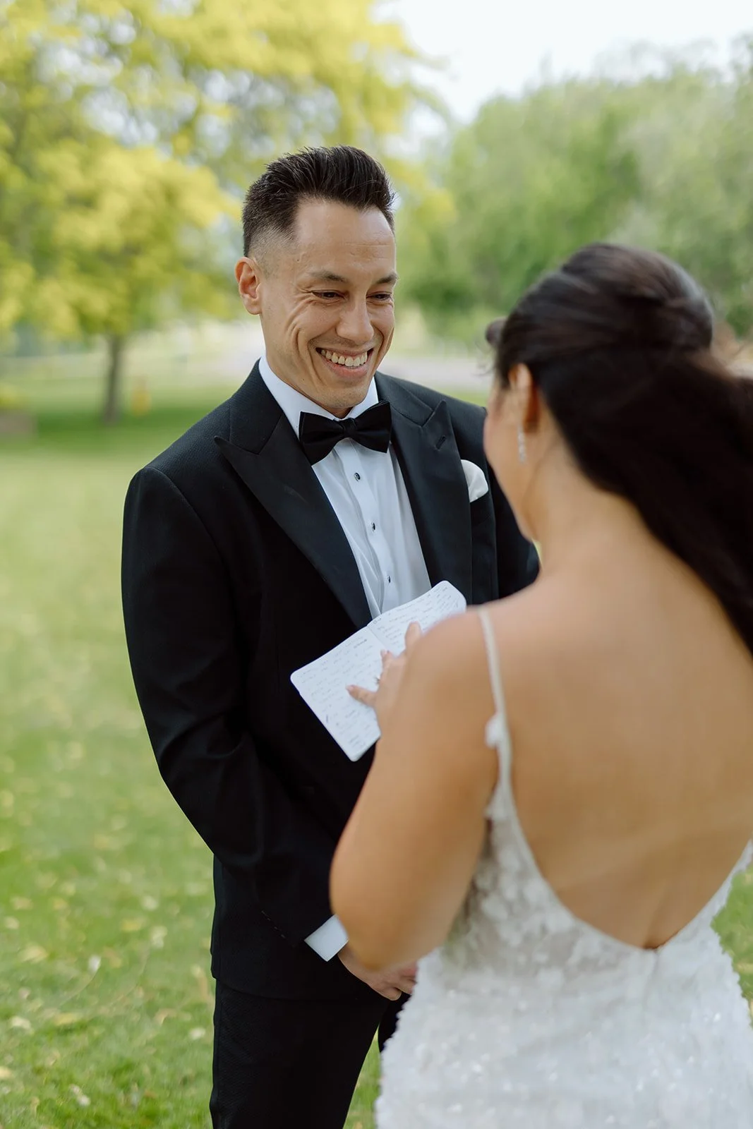  Groom smiling emotionally during a wedding first look and private vow exchange at a Niagara vineyard. 
