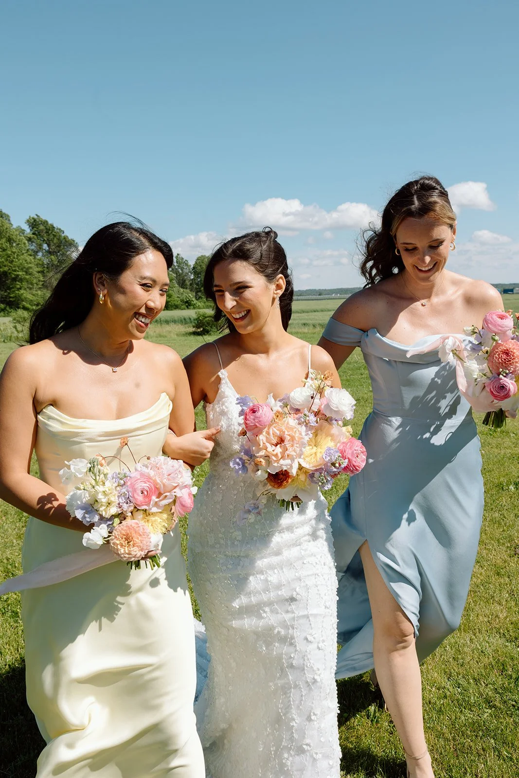  Mismatched pastel bridesmaid dresses in light blue and soft yellow for a summer wedding. 