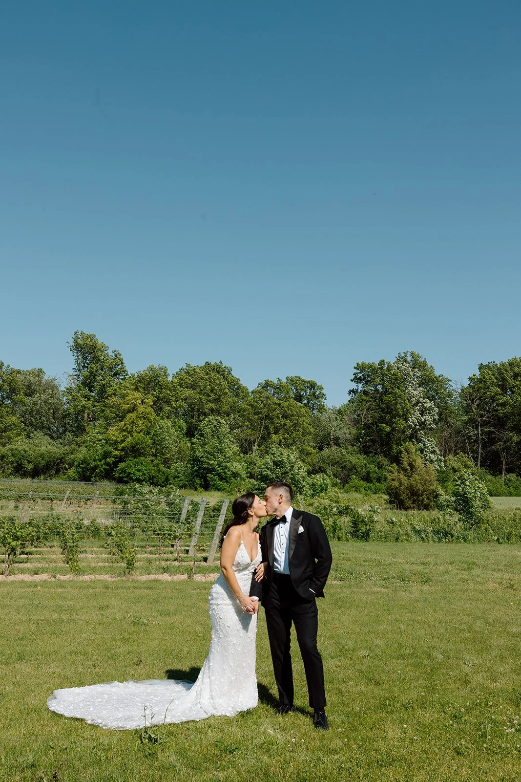  Groom wearing a classic black tuxedo and bow tie for a modern romantic wedding. 