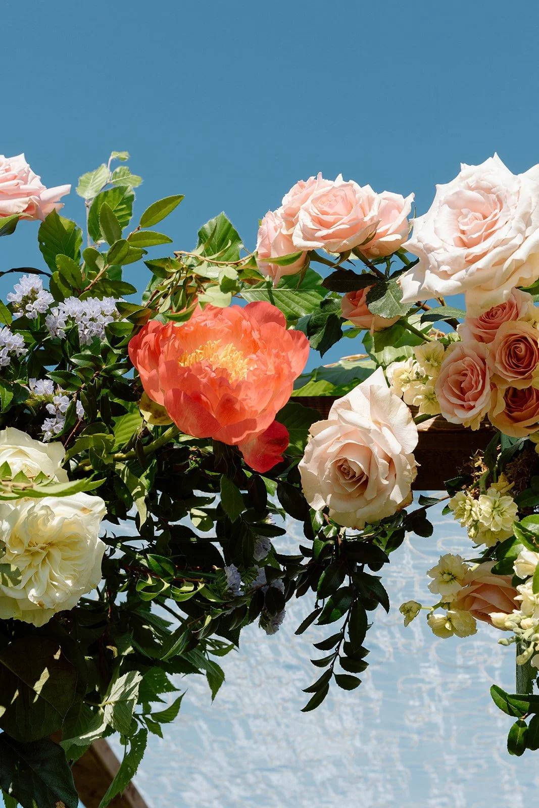  Vibrant garden-style wedding arch floral installation designed by Threads &amp; Blooms for a luxury outdoor winery wedding planned by Lindsay Plank Events. 