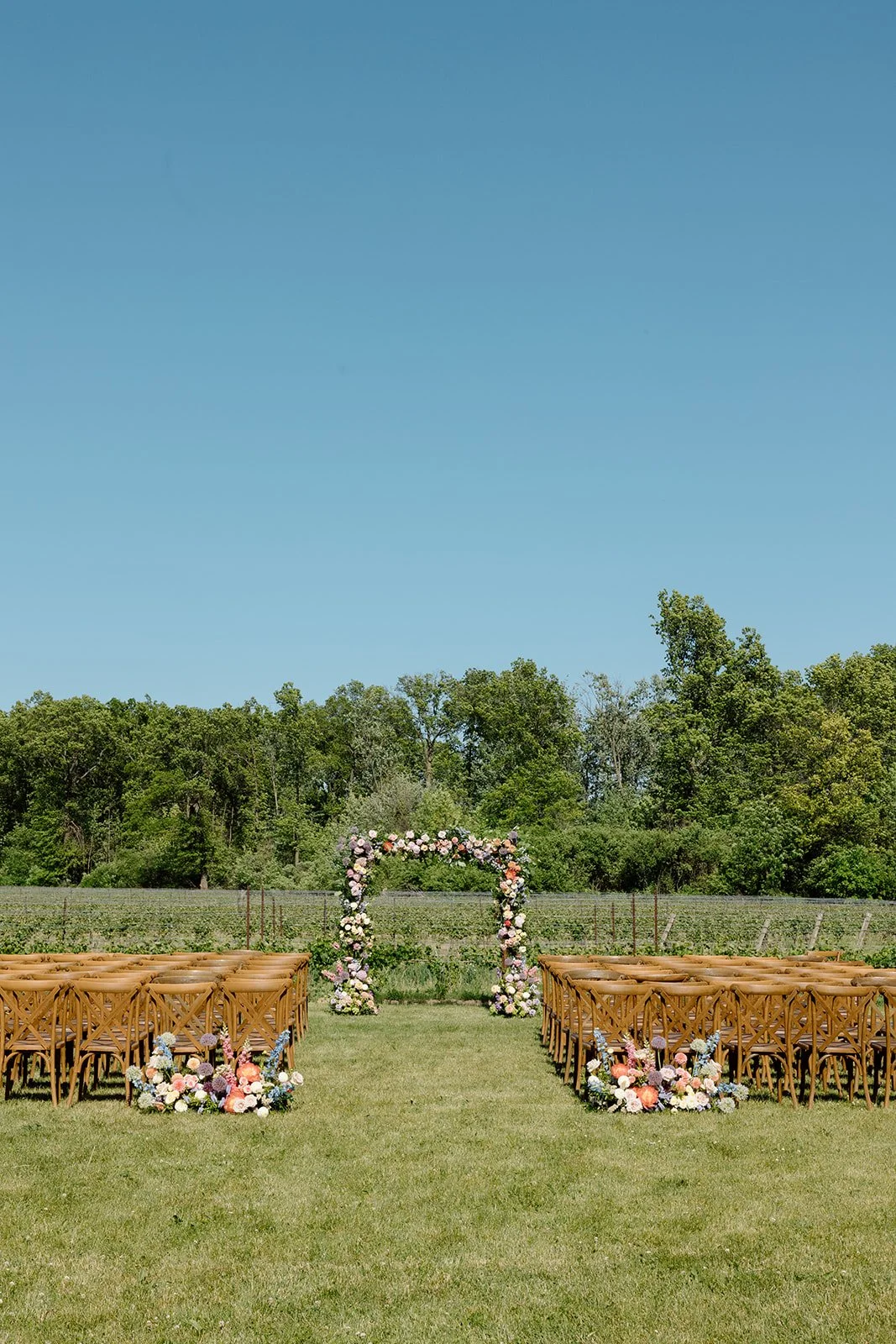  Outdoor Jewish wedding ceremony under a lush, flower-covered wooden chuppah overlooking the vineyard at The Hare Wine Co. 