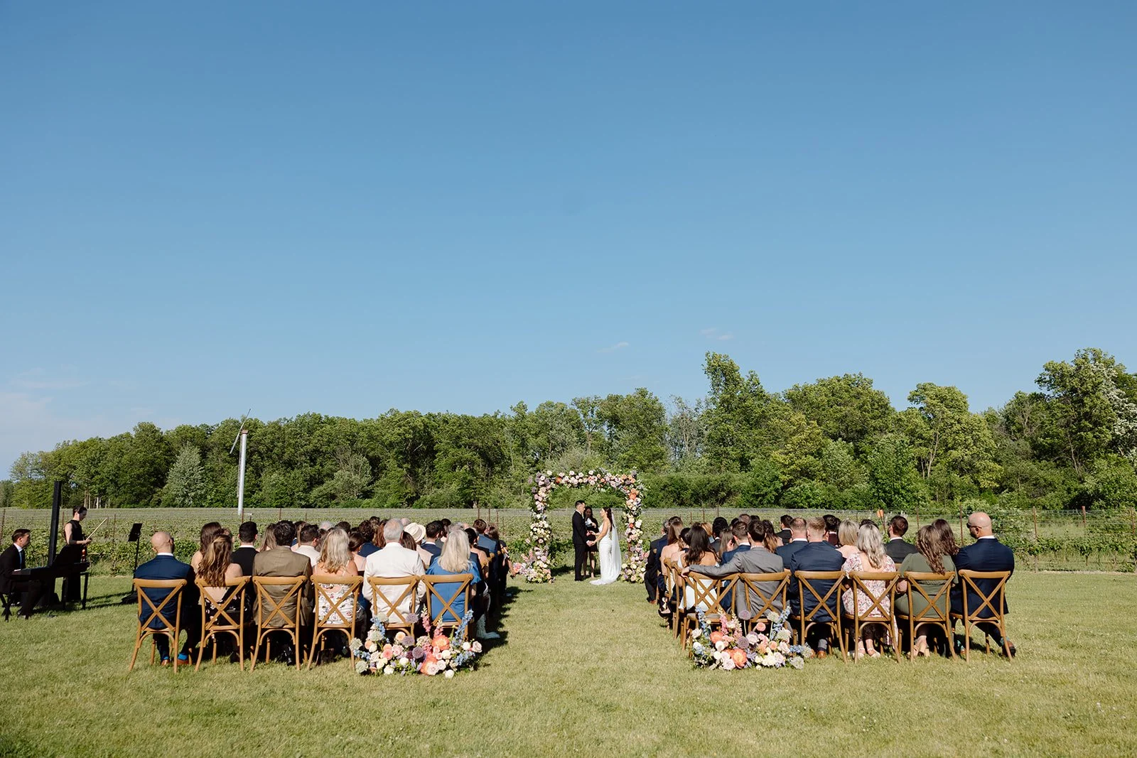  Colourful winery wedding ceremony designed by Niagara wedding planner Lindsay Plank Events, featuring lush chuppah florals by Threads &amp; Blooms and captured by Paula Visco. 