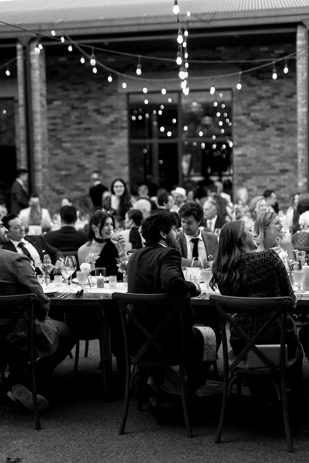  Guests toast to the couple under the golden hour sun for their wedding at The Hare Wine Co. within the courtyard. 