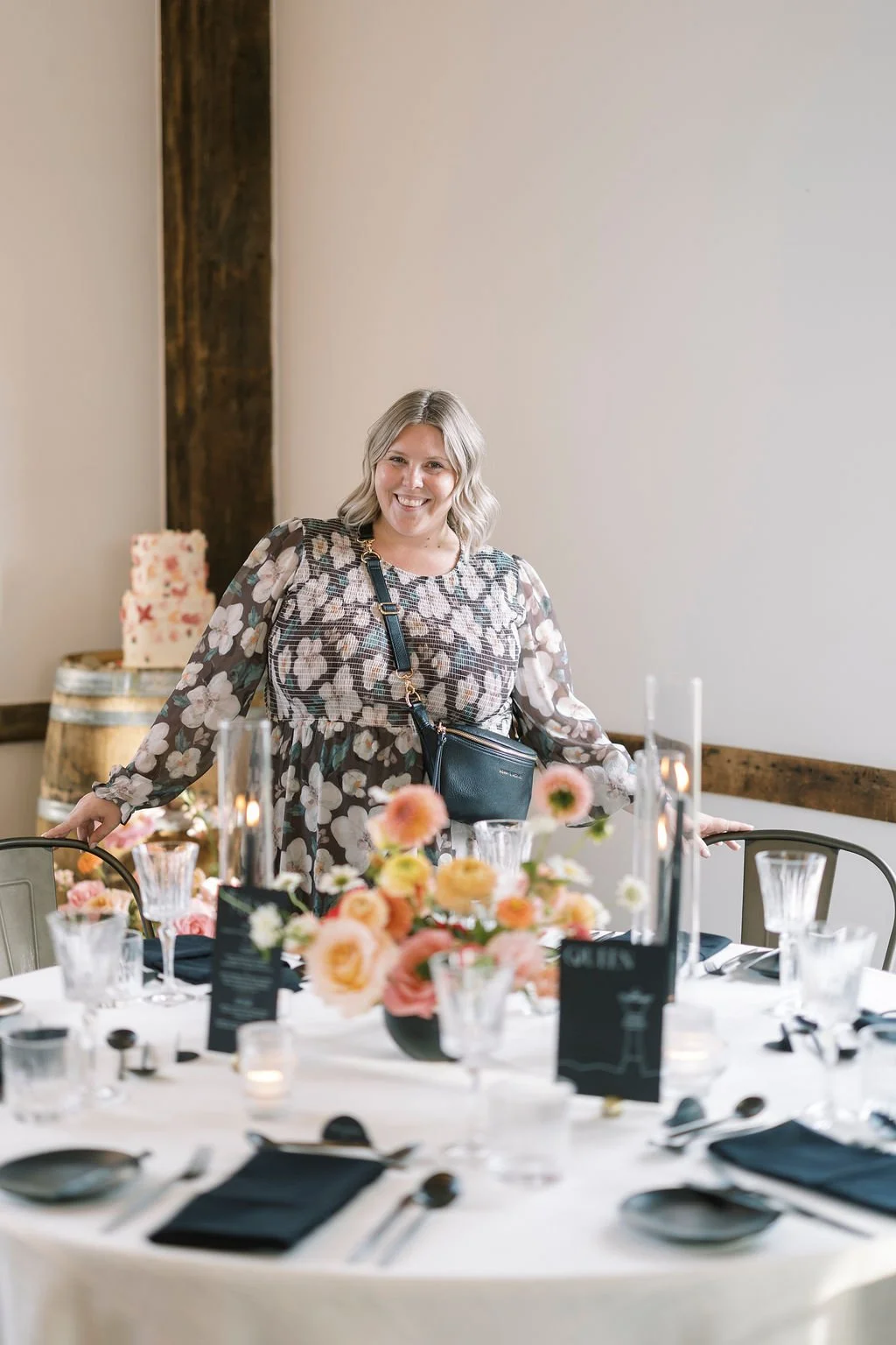 Lindsay arranging a flatlay featuring a gorgeous soft pink bouquet and white heeled shoes | questions to ask your wedding planner