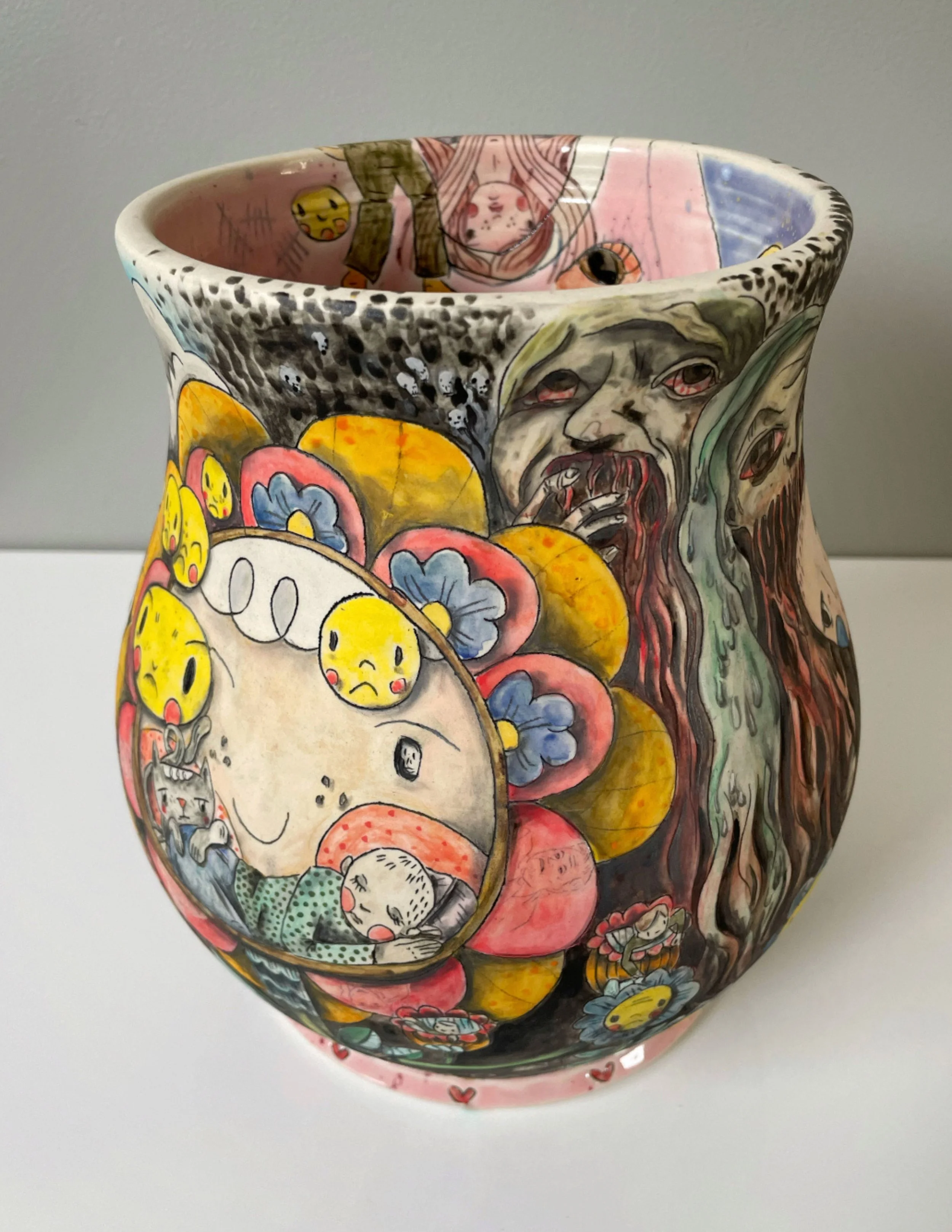 Colorful ceramic vase decorated with expressive, surreal illustrations of faces, characters, and abstract shapes.