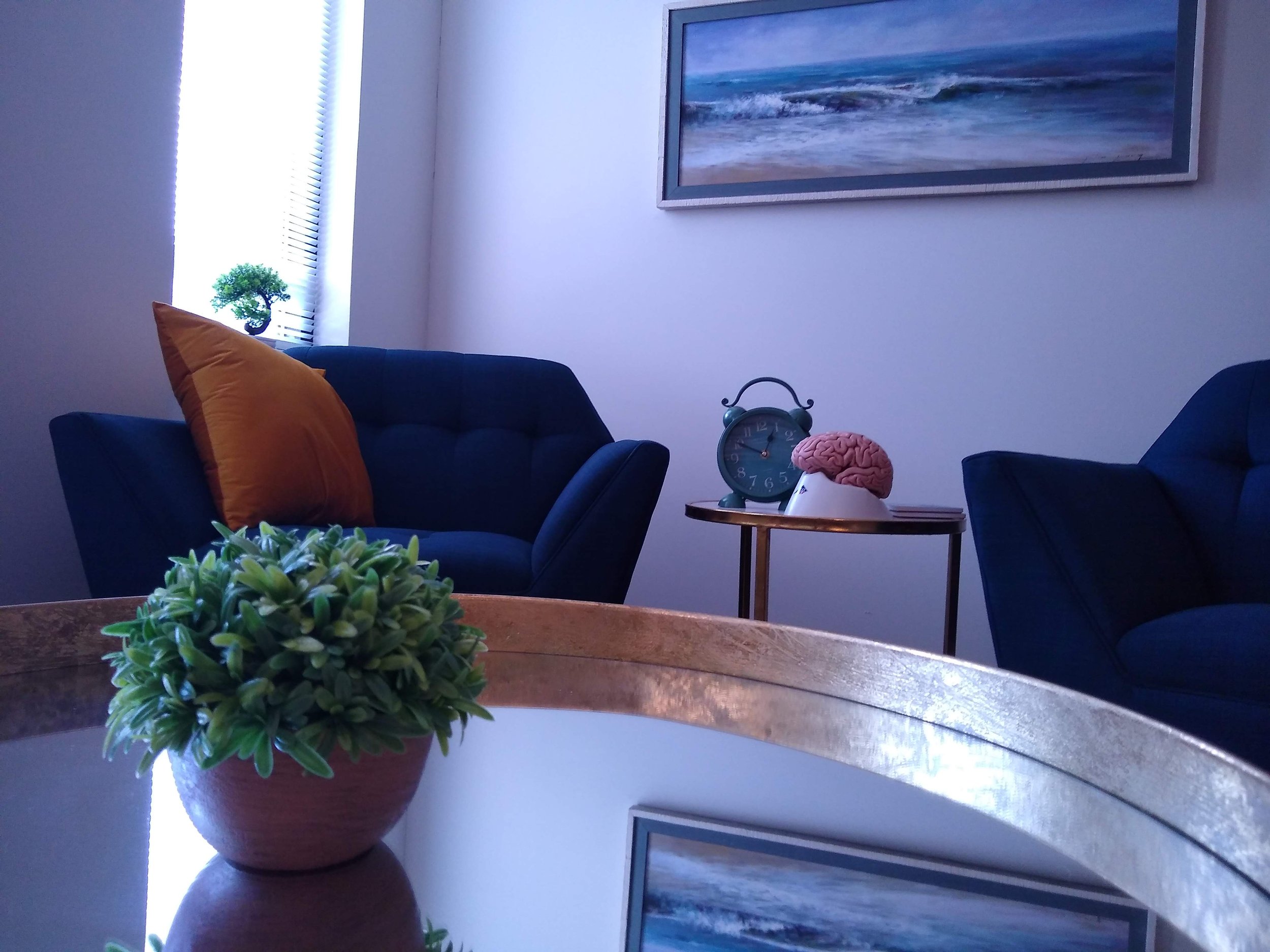 Picture of two chairs with a small coffee table in between.