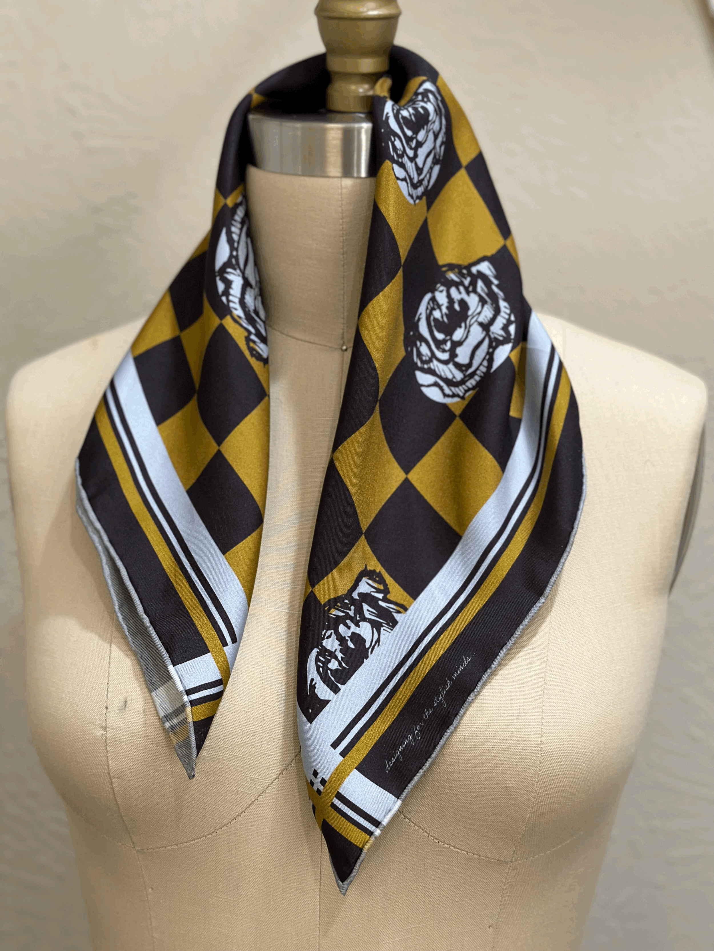 A gorgeously patterned 100% silk scarf, designed by Crisp Olive™ Studio. A checkered background of olive and black and light blue roses. A fashion statement to style up outfits instantly.