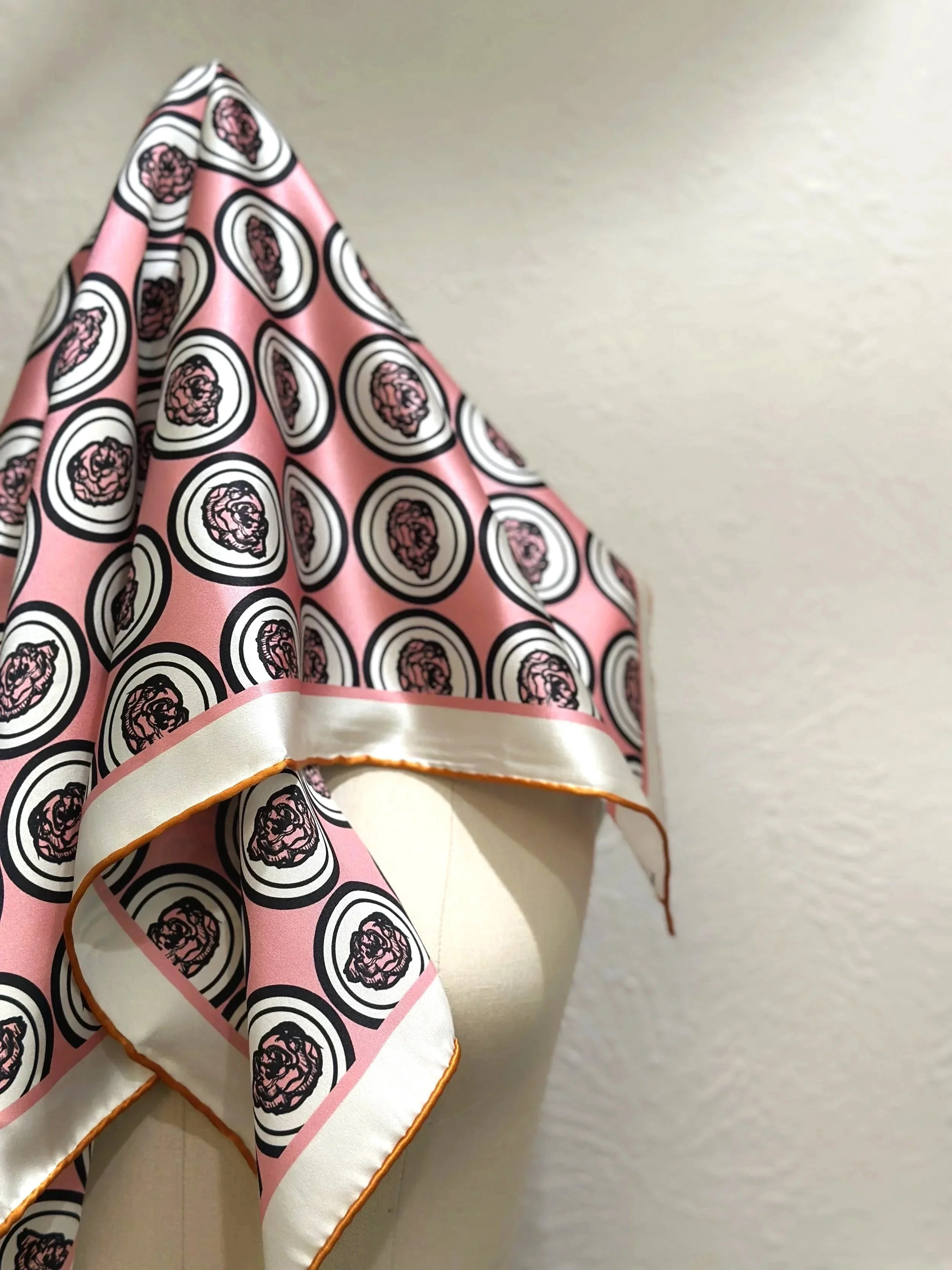 Sophisticated, artist designed silk scarf in an all over floral pattern in dusty pink, creme, light orange and classic black colors.