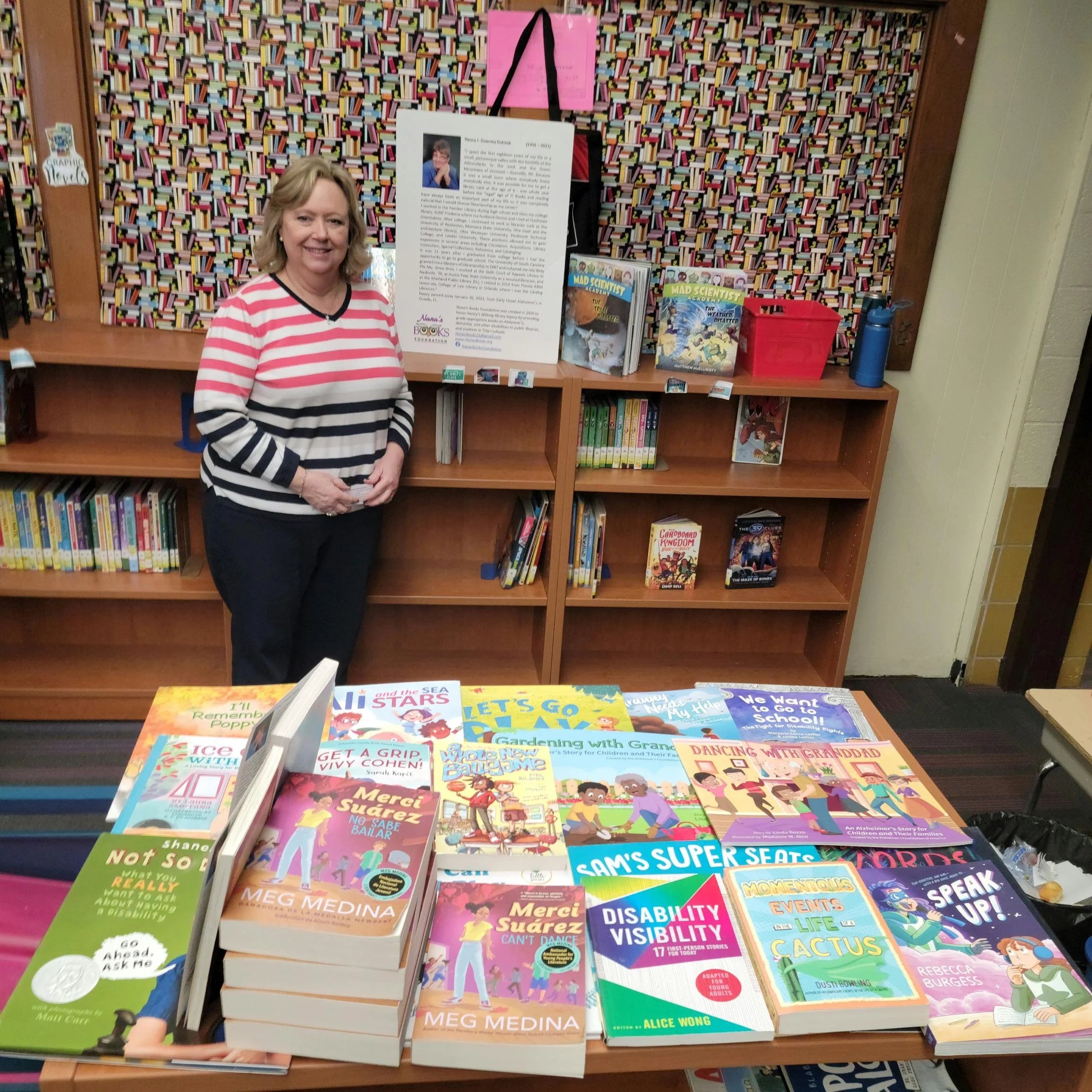 Owings Mills Elementary librarian Lisa Fletcher stands behind a collection of books donated by Nana’s Books Foundation.