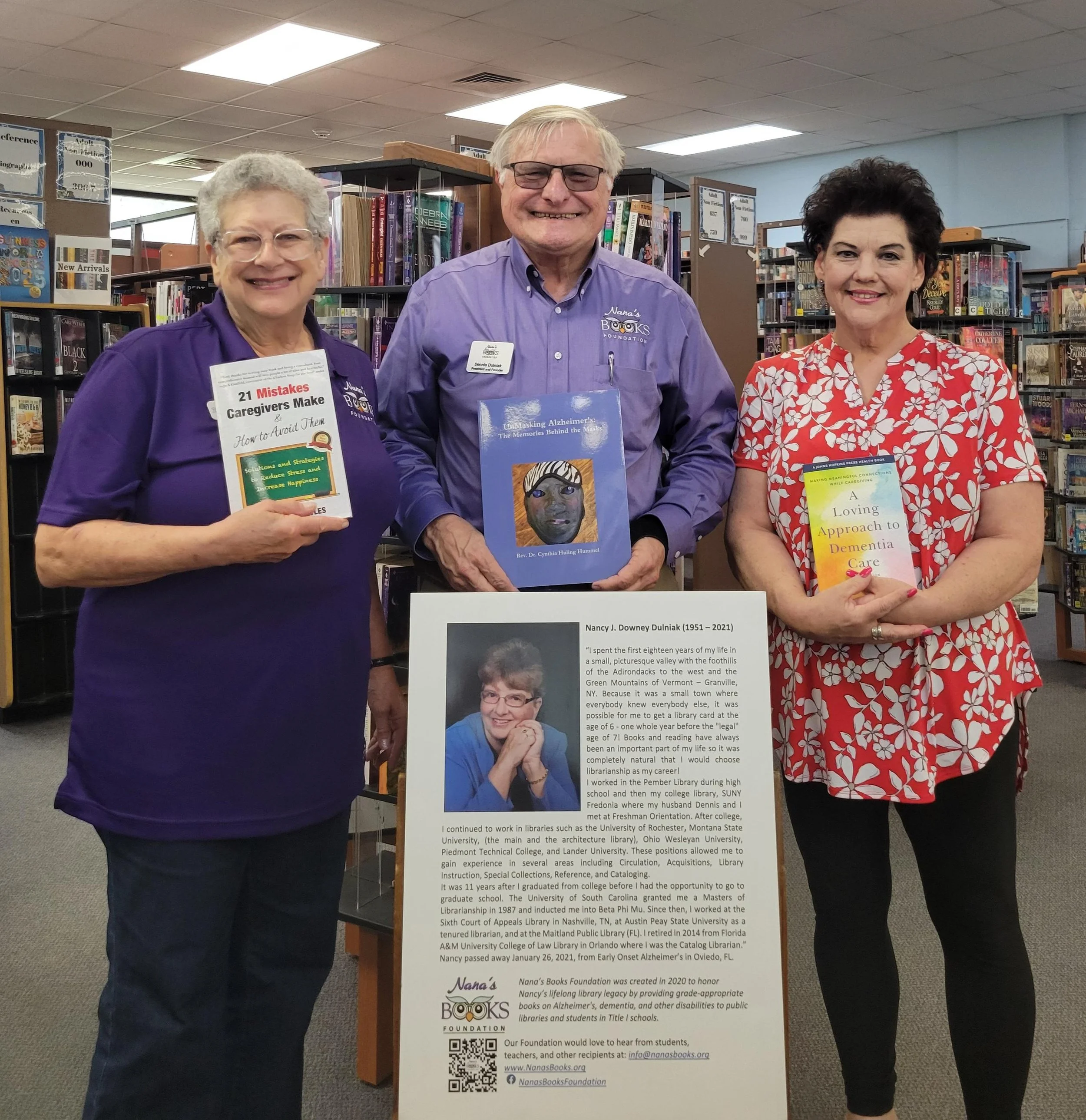 Nana’s Books Foundation representatives display caregiving, Alzheimer’s, and dementia resources donated to a public library.