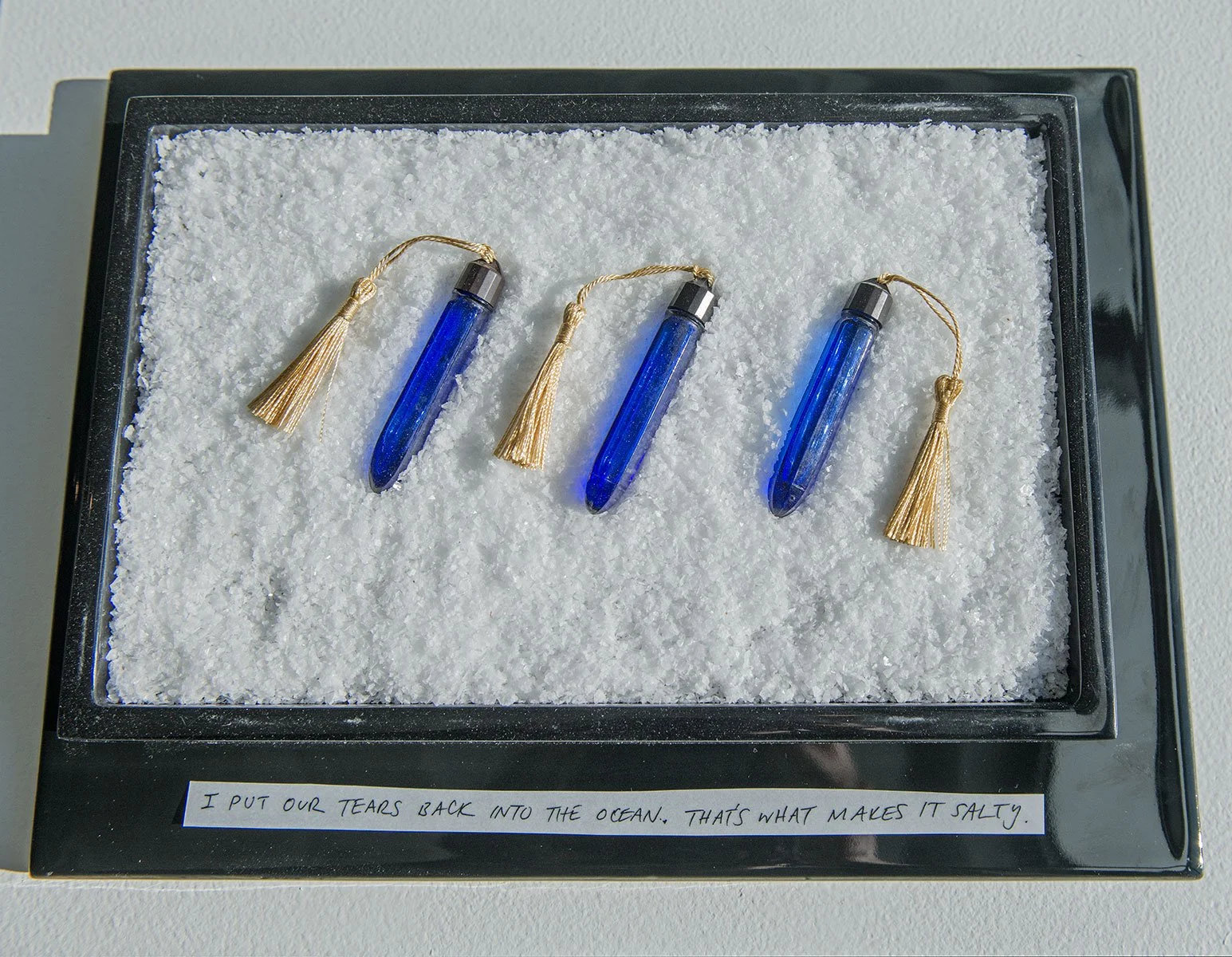 'The Lachrymist (Artists’ Tears As Invisible Ink)', 2025, human tears, found glass vials, tassels, grief, acrylic tray, sea salt, vitreous porcelain, incantation.
Altar Incantation: "I Put Our Tears Back Into The Ocean, That's What Makes It Salty."