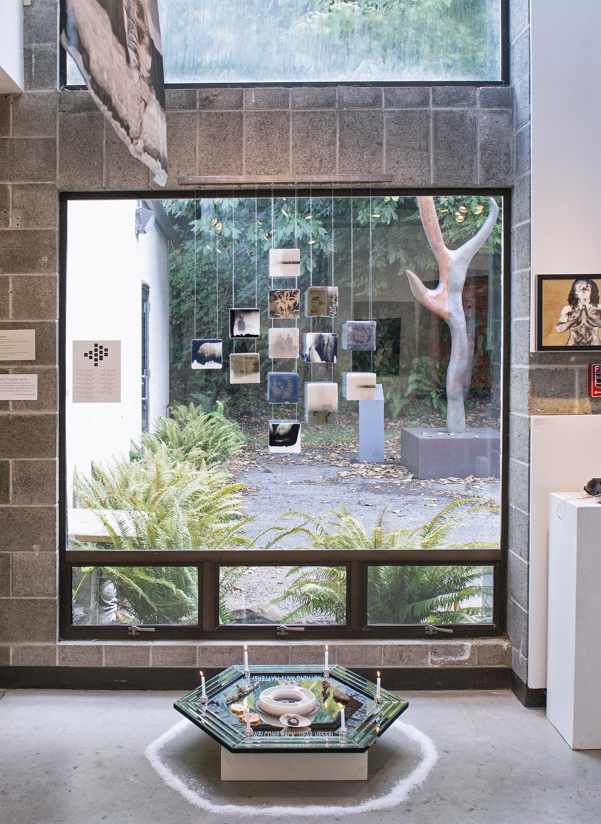 Installation view: Glass tiles with decals, Dardinelle Troen, 2026, 5 x 5 x .25 inches each, 
Hexagoner (She’s Mantic), Marne Lucas, 2026.