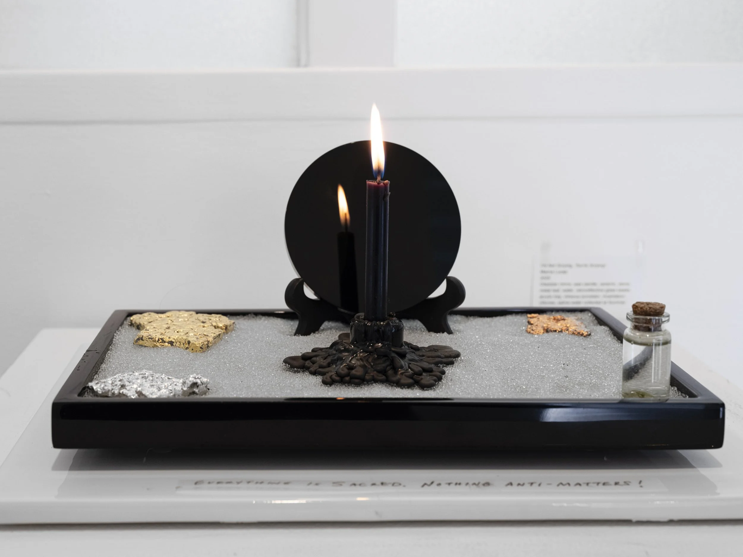 'I’m Not Scrying, You're Scrying!', 2025,
Obsidian mirror, wax candle, ceramic, stone, metal leaf, water, retroreflective glass beads, acrylic tray, vitreous porcelain.
(Saline water collected at the mouth of the Columbia River, Oregon.)

