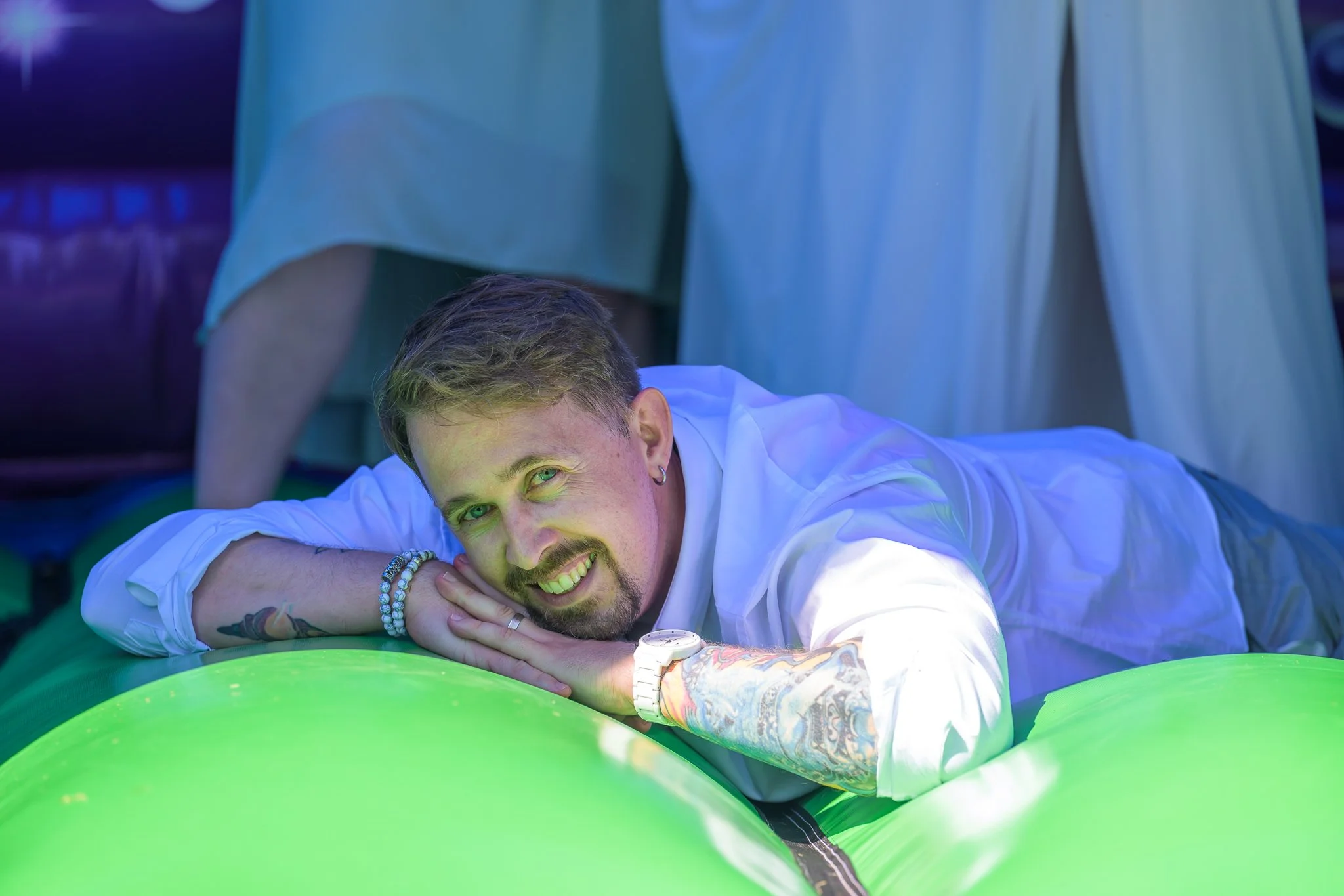 A groom laying down on a bouncy castle