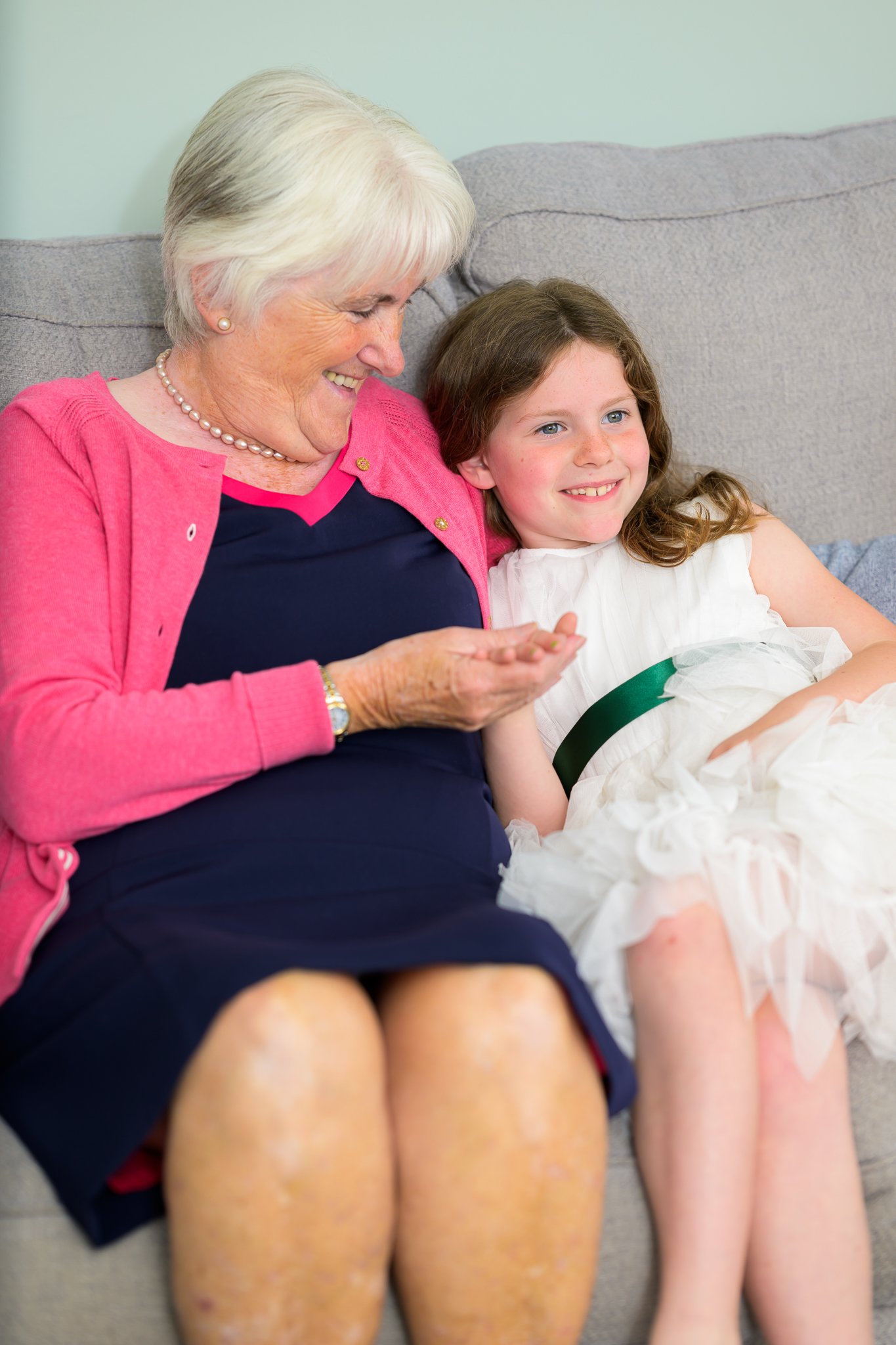 The brides mother and child sat on a sofa