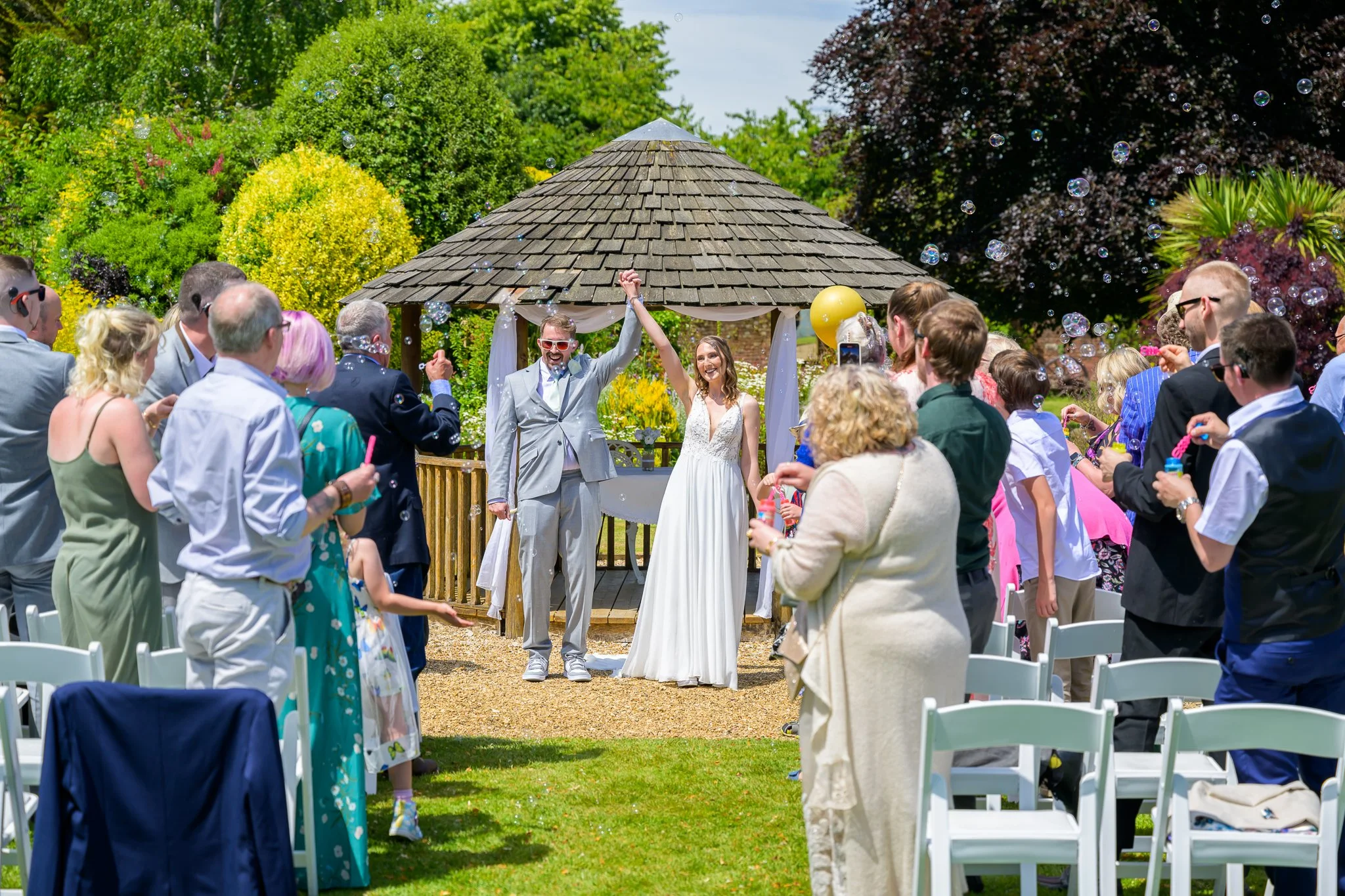 A bride and groom cheering after just saying their wedding vows