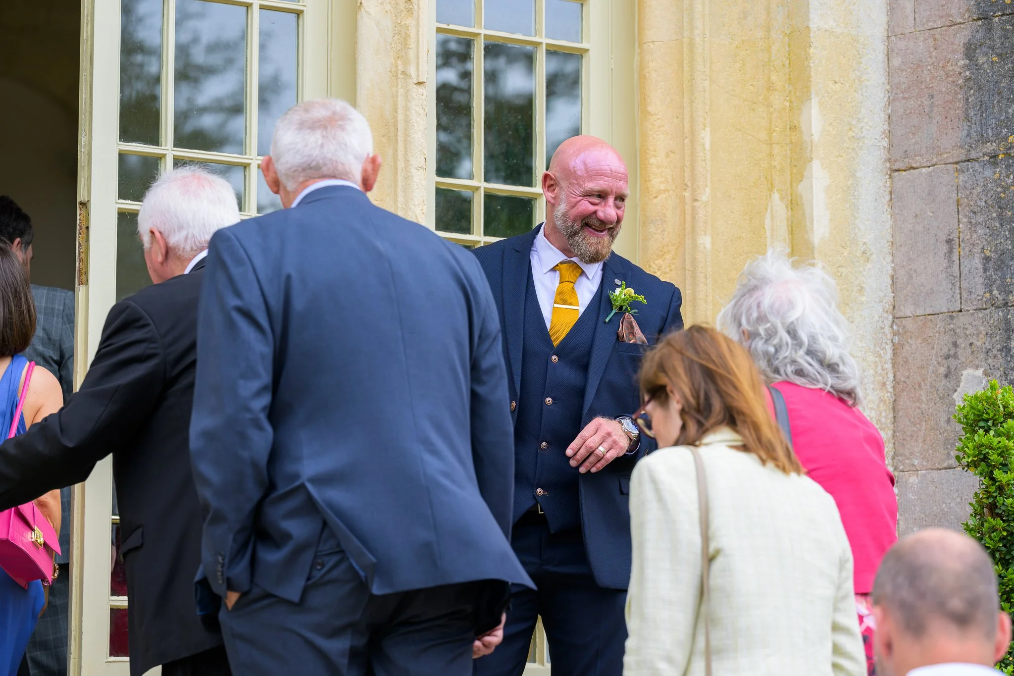 Groom stood with his wedding guests outside the wedding venue 