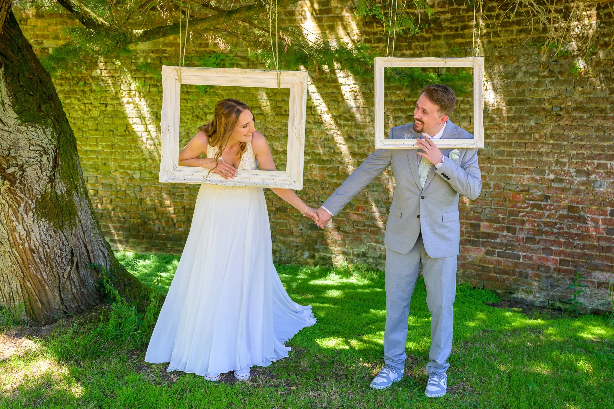 A bride and groom poking their heads through canvas'