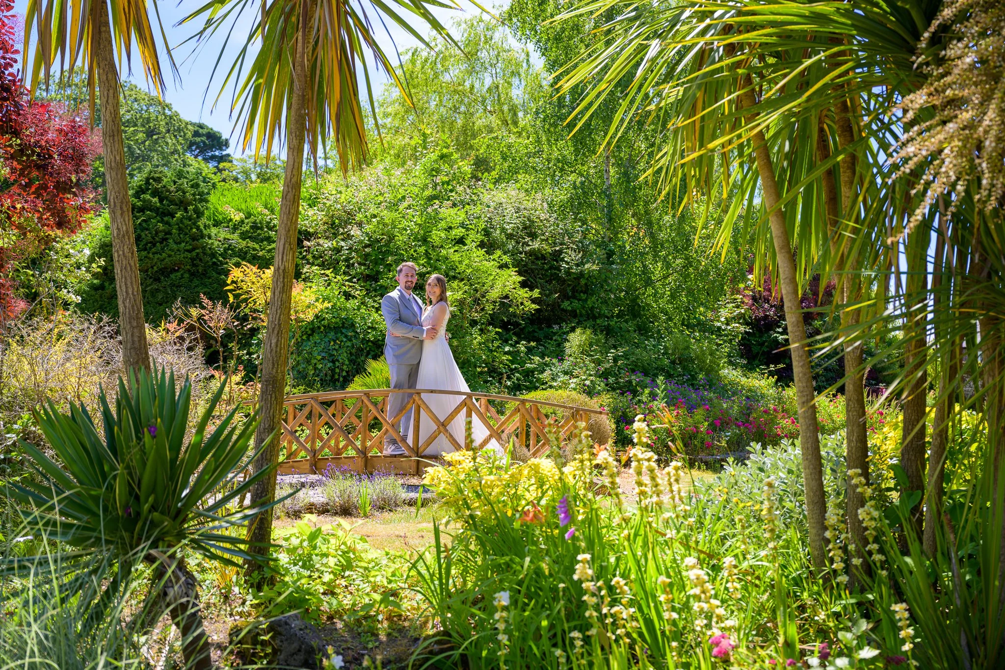 A bride and groom posing and hugging on a bridge