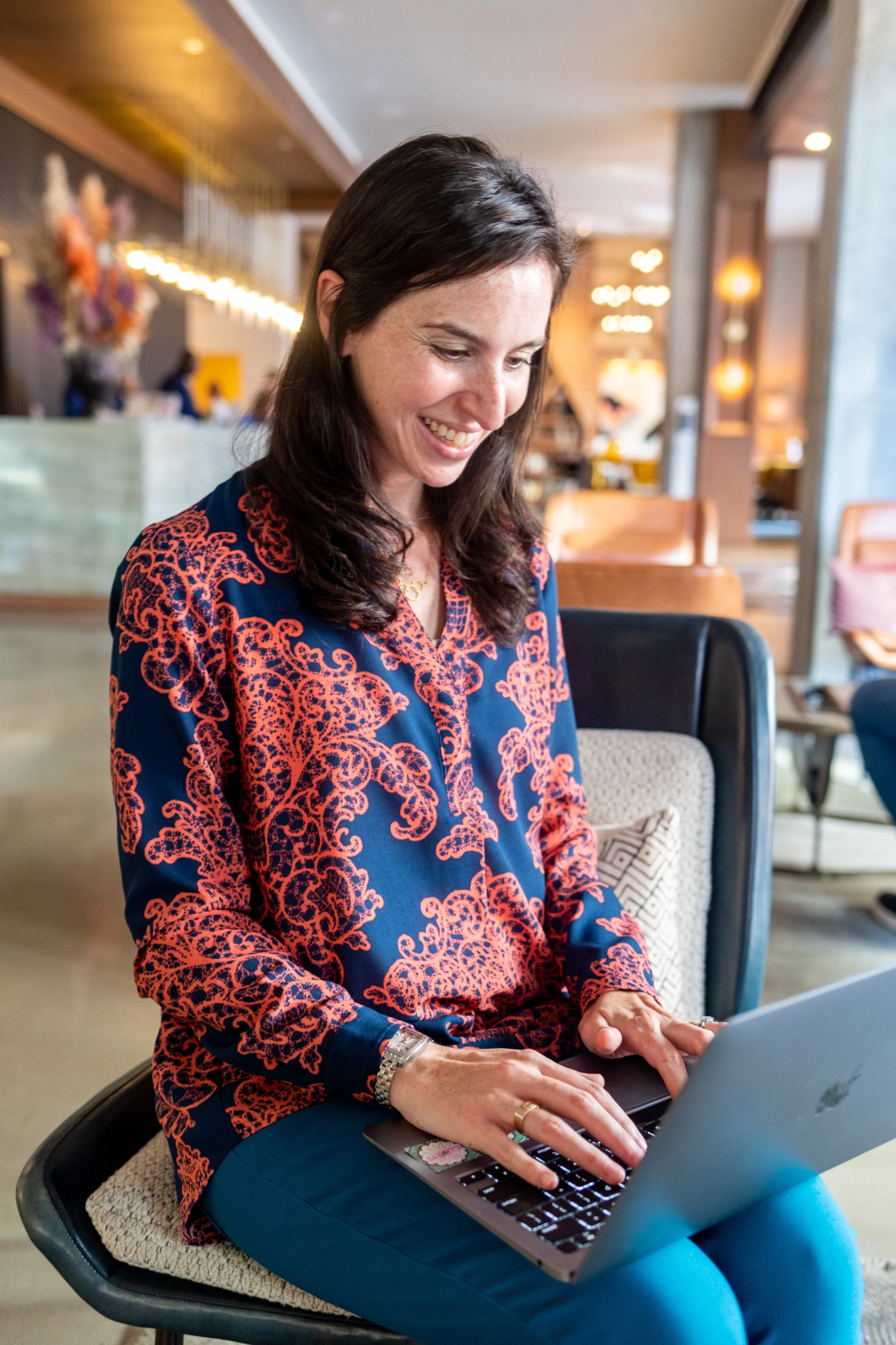 Voice for Good founder Jordana Merkin sits at a computer smiling
