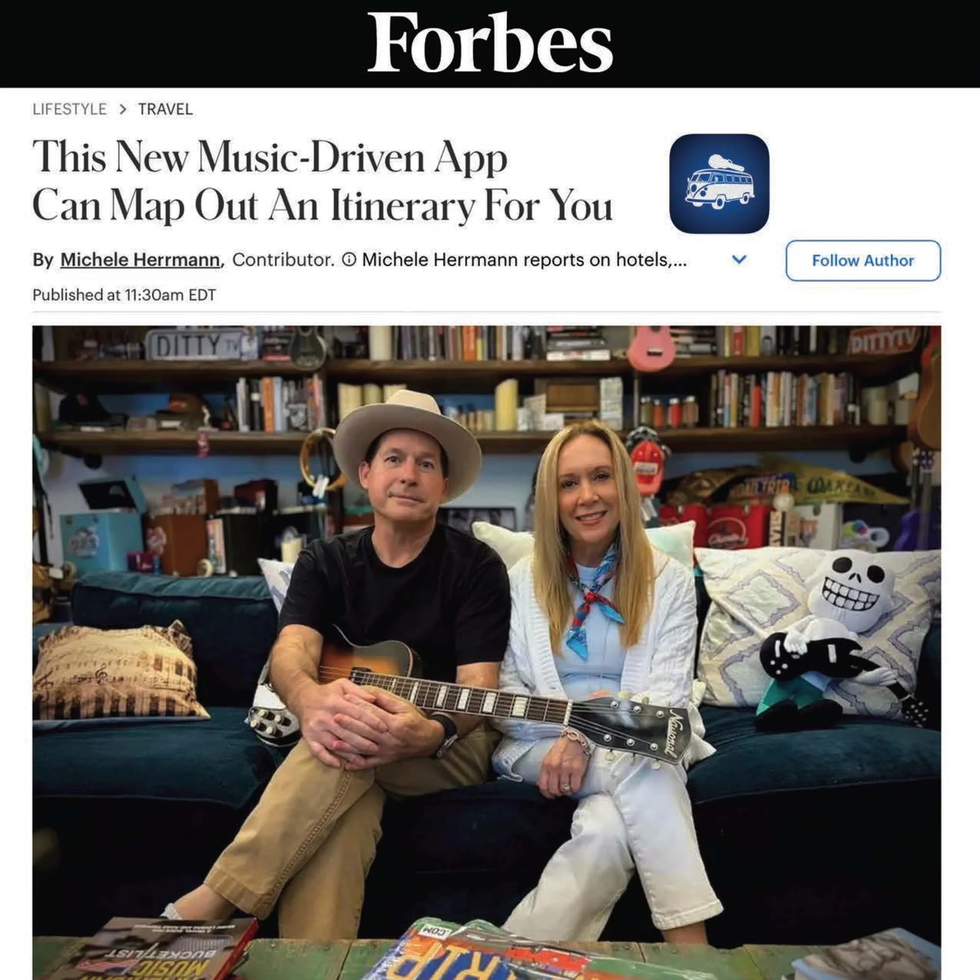 Two people sitting on a couch with a guitar; a man wearing a hat and black t-shirt, a woman with blonde hair and white clothing; in a room with shelves filled with books and decorations.